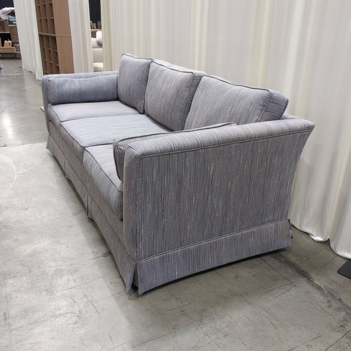 Textured Gray Three-Cushion Couch with Skirted Base