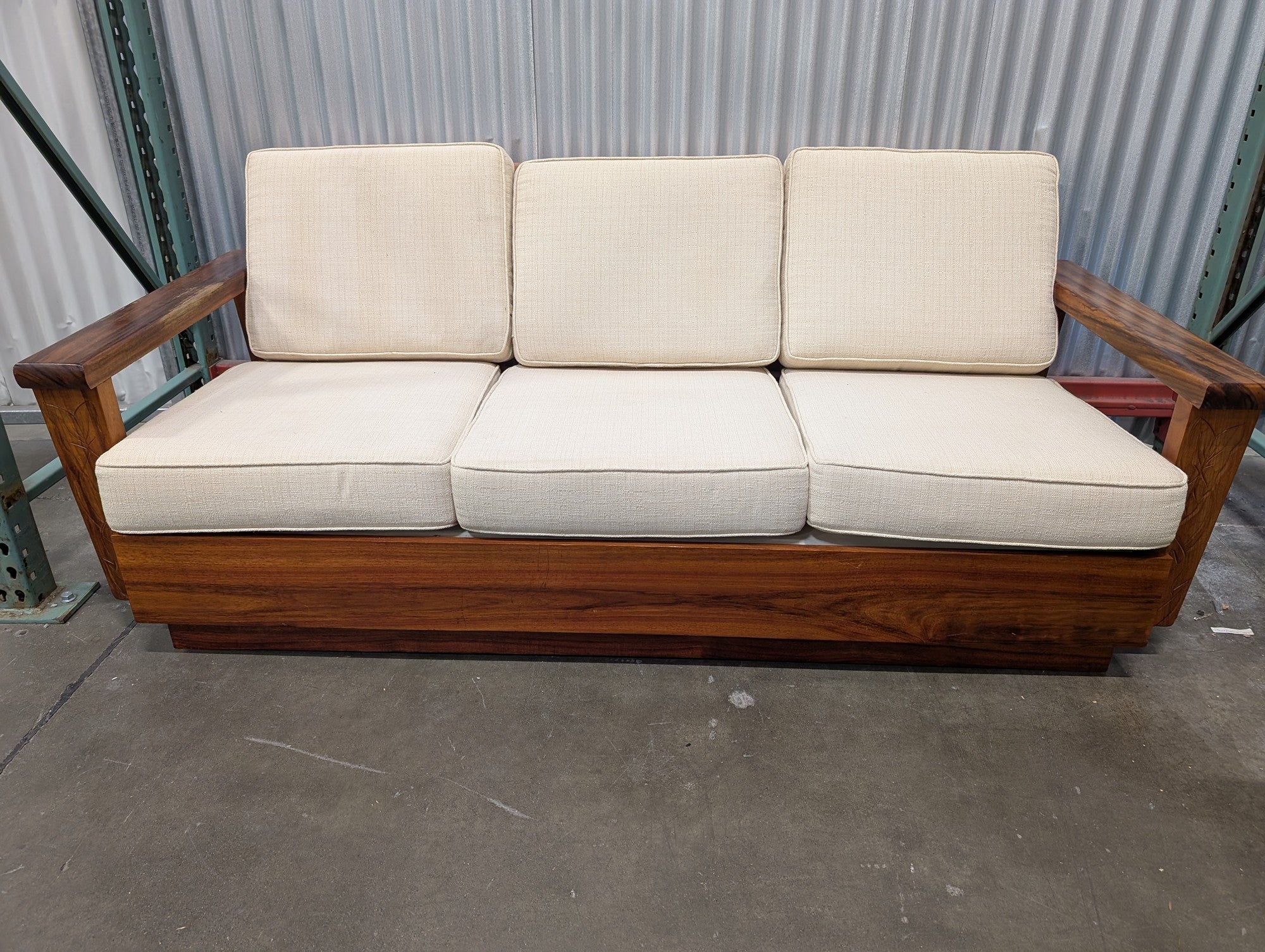 Mid-Century Style Wooden Sofa with Carved Leaf Arms and Cream Cushions