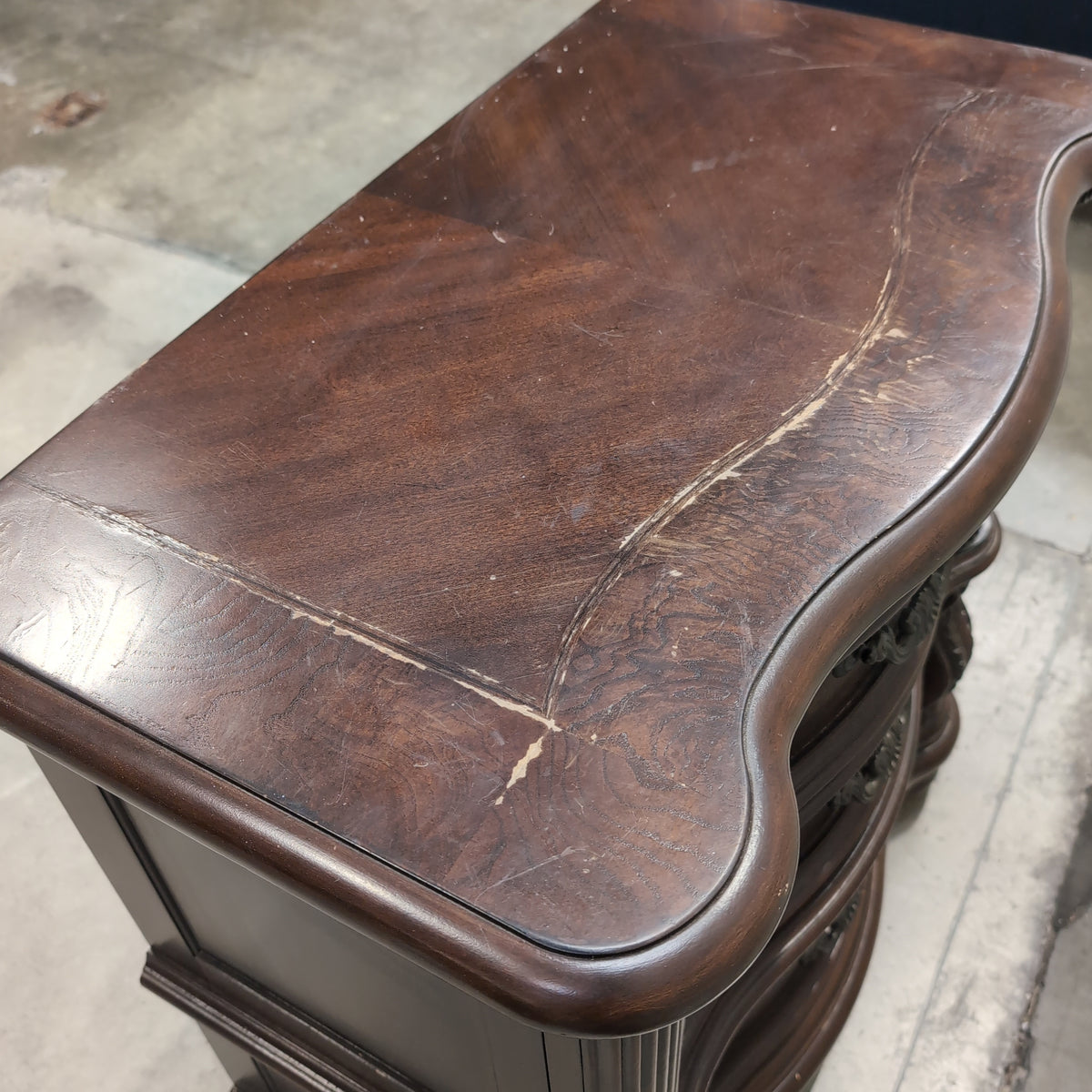 Dark Wood Three-Drawer Nightstand with Ornate Hardware
