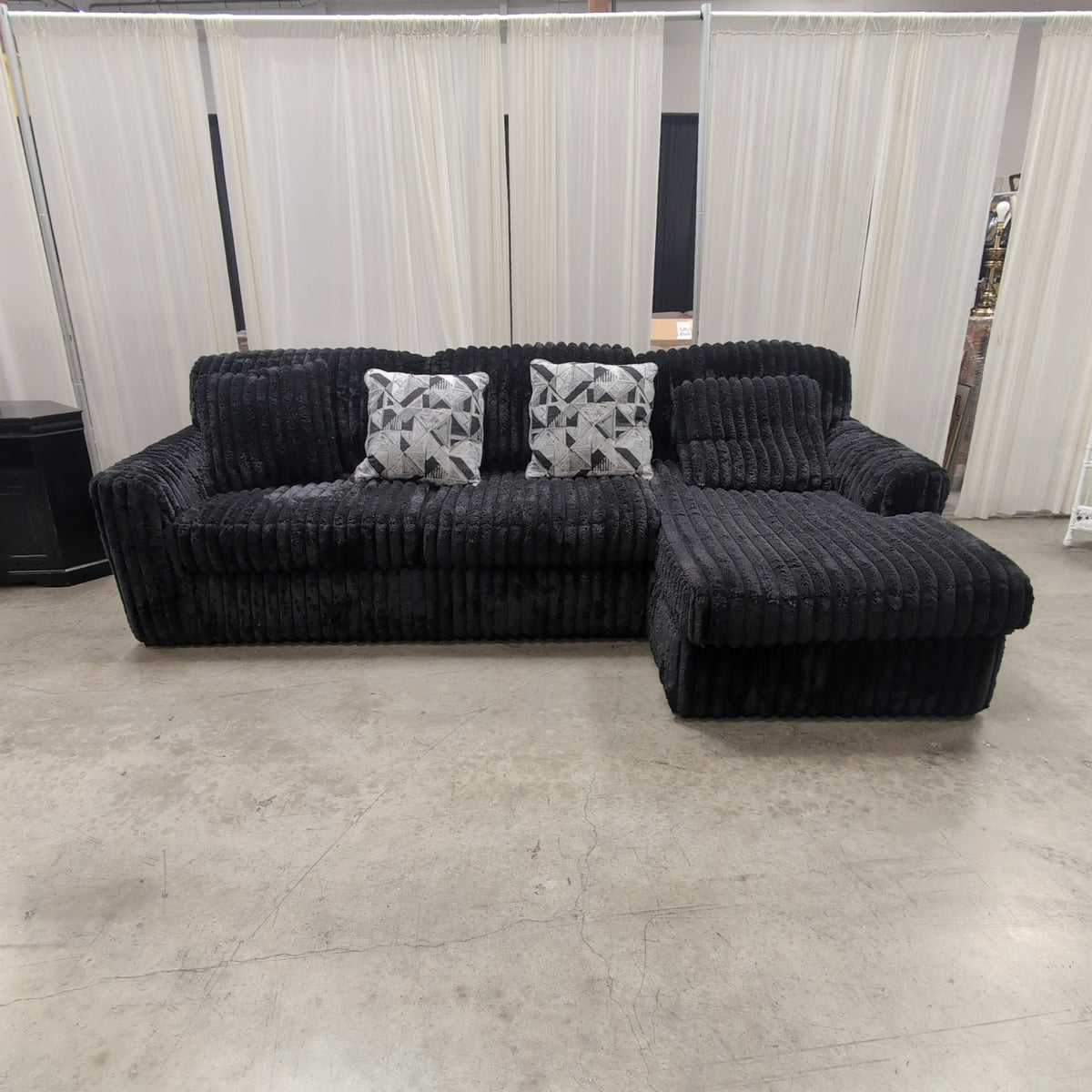 Black Ribbed Plush Sectional Couch with Geometric Throw Pillows
