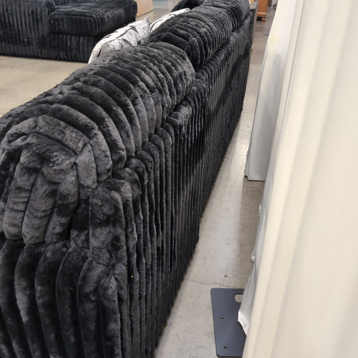 Black Ribbed Plush Sectional Couch with Geometric Throw Pillows