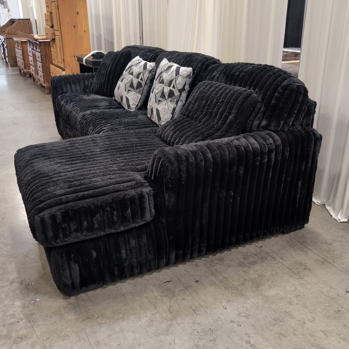 Black Ribbed Plush Sectional Couch with Geometric Throw Pillows