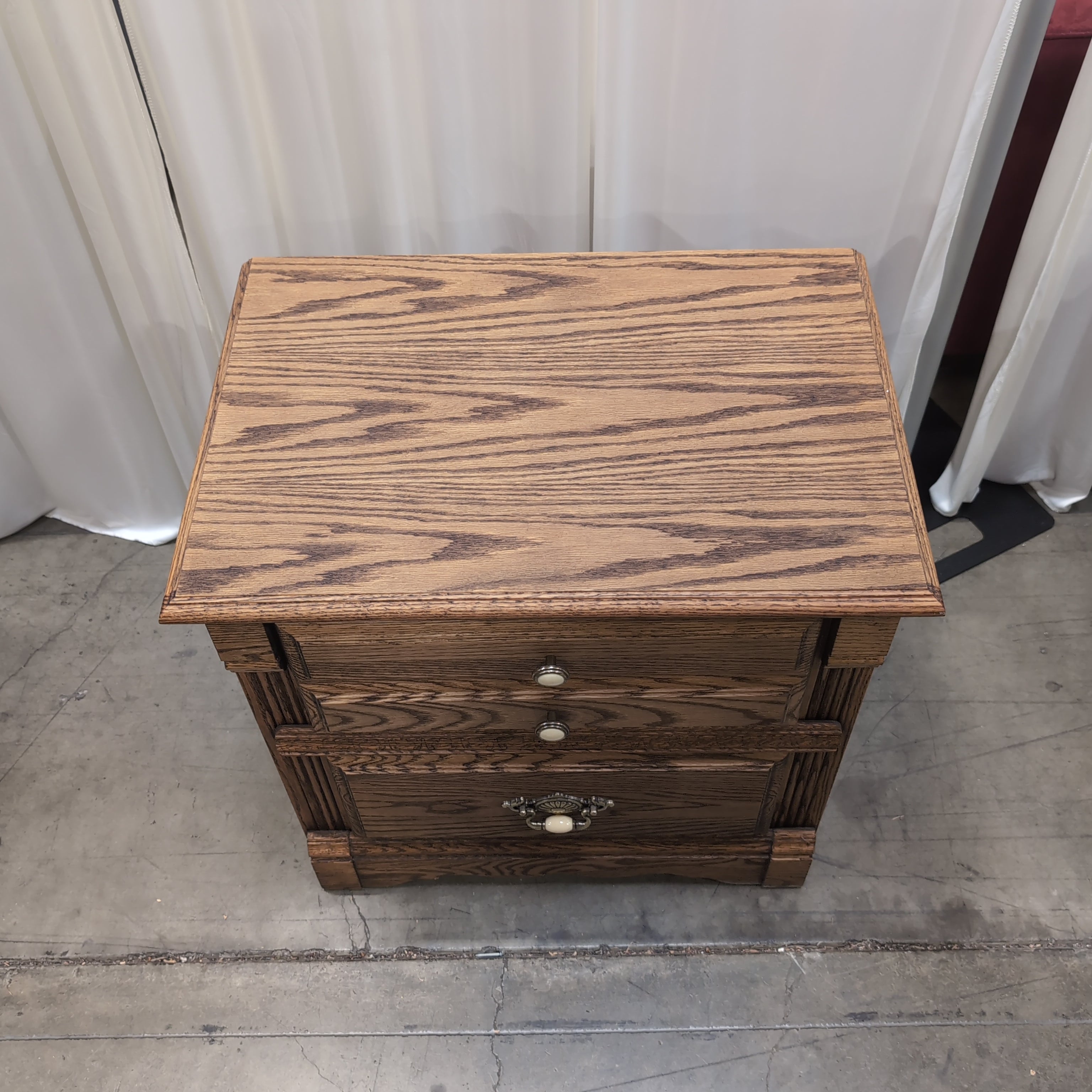 Brown Wood Three-Drawer Nightstand with Ornate Hardware