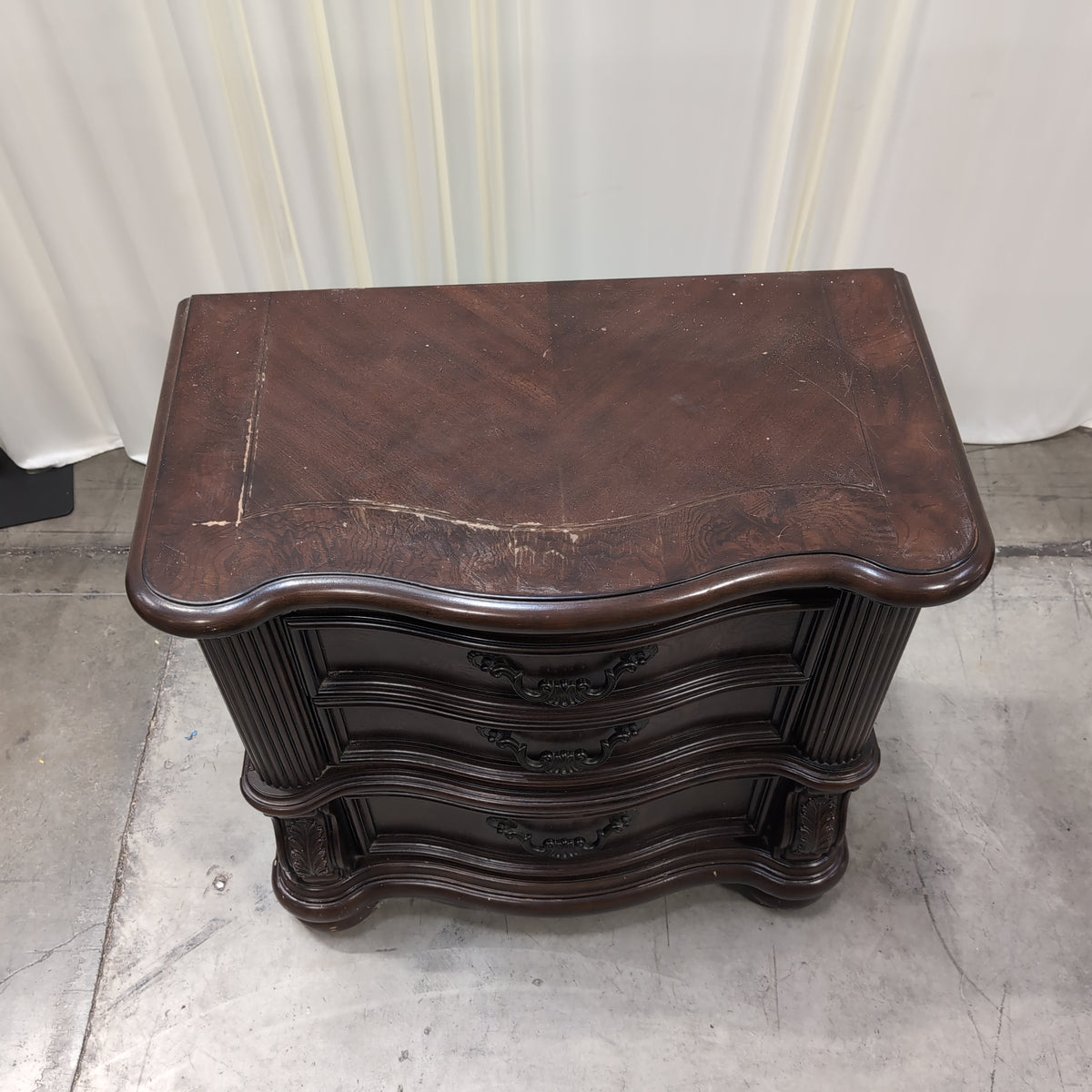 Dark Wood Three-Drawer Nightstand with Ornate Hardware
