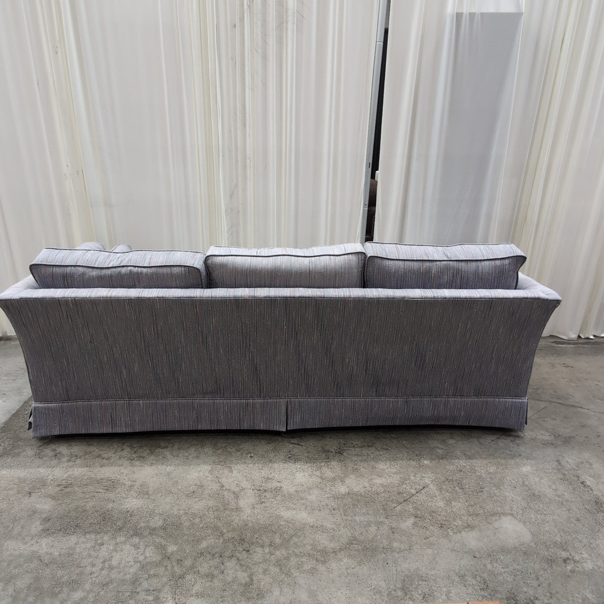 Textured Gray Three-Cushion Couch with Skirted Base