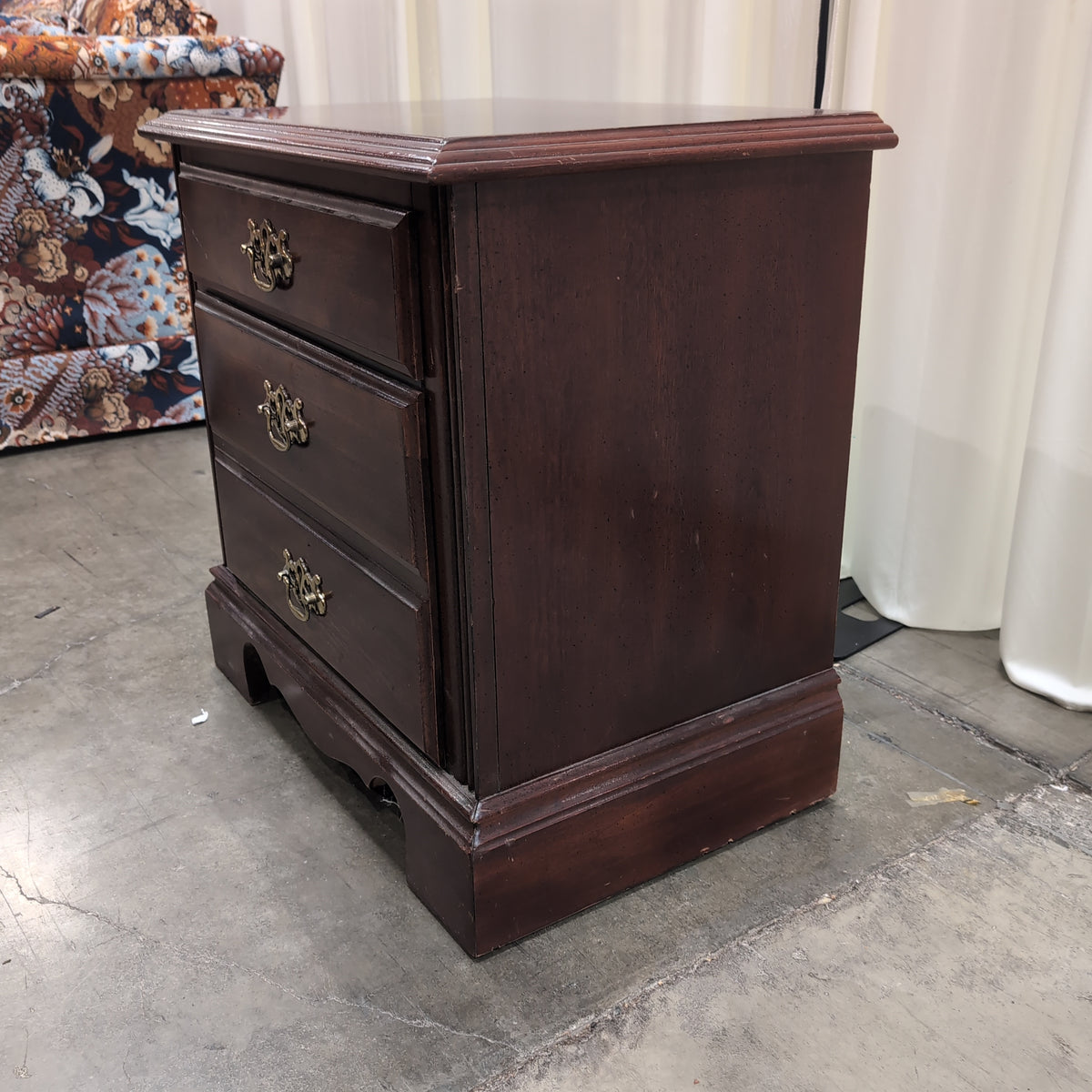 Traditional Dark Wood Three-Drawer Nightstand with Ornate Hardware