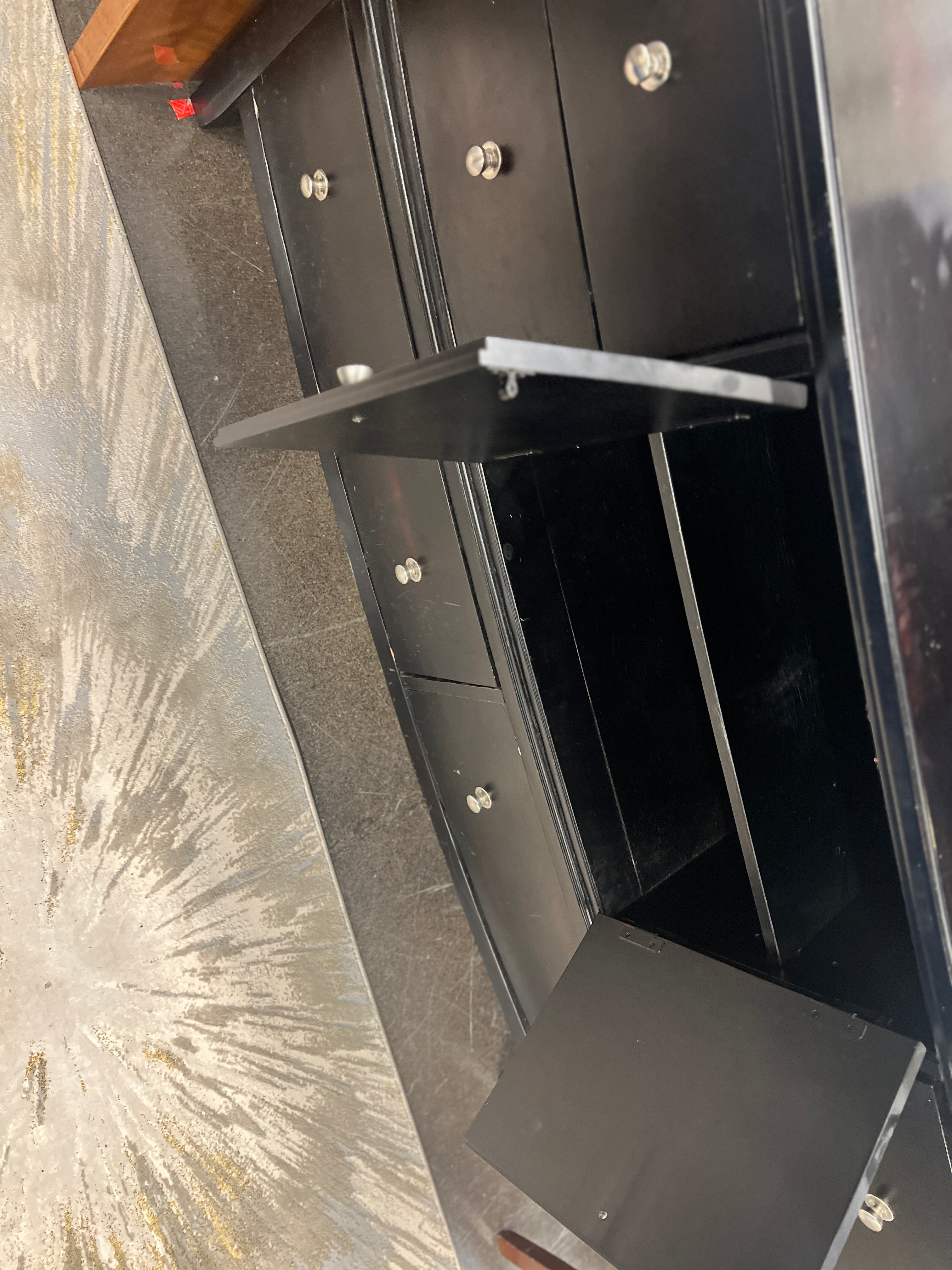 Curved black dresser with silver knobs