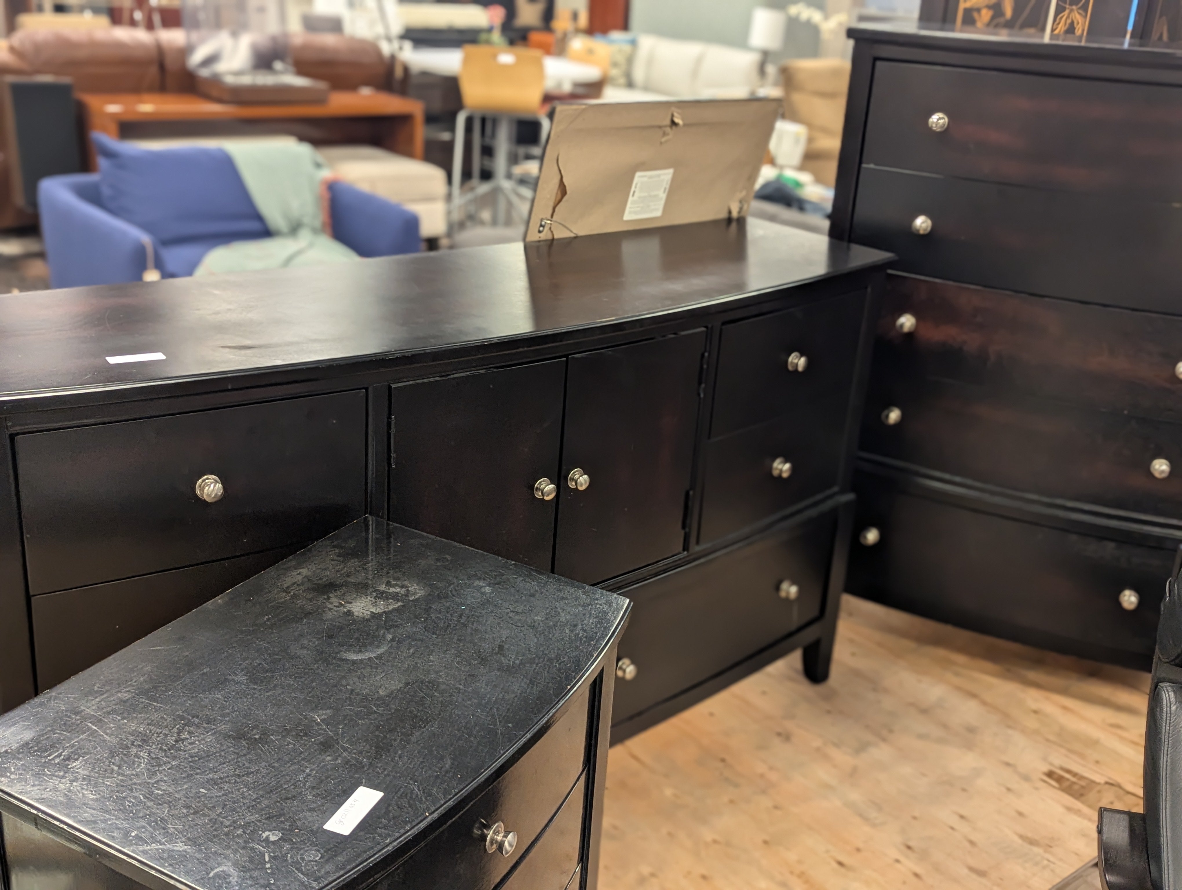 Curved black dresser with silver knobs