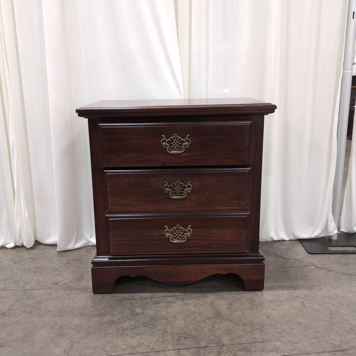 Dark Wood Three-Drawer Nightstand with Ornate Hardware