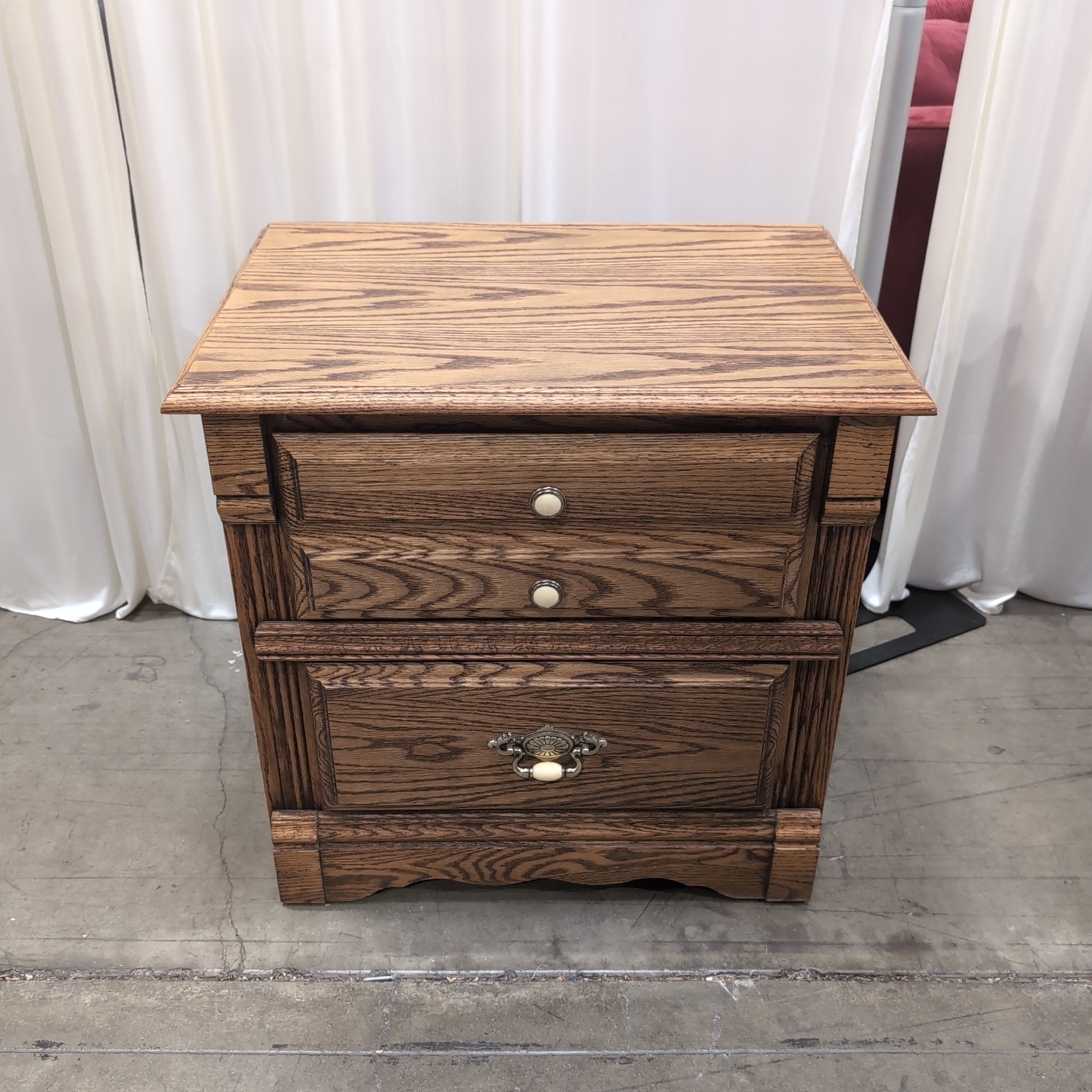 Brown Wood Three-Drawer Nightstand with Ornate Hardware