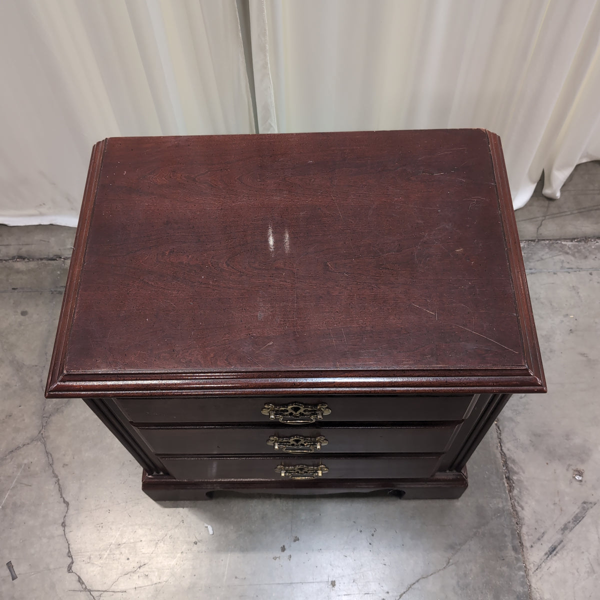 Traditional Dark Wood Three-Drawer Nightstand with Ornate Hardware