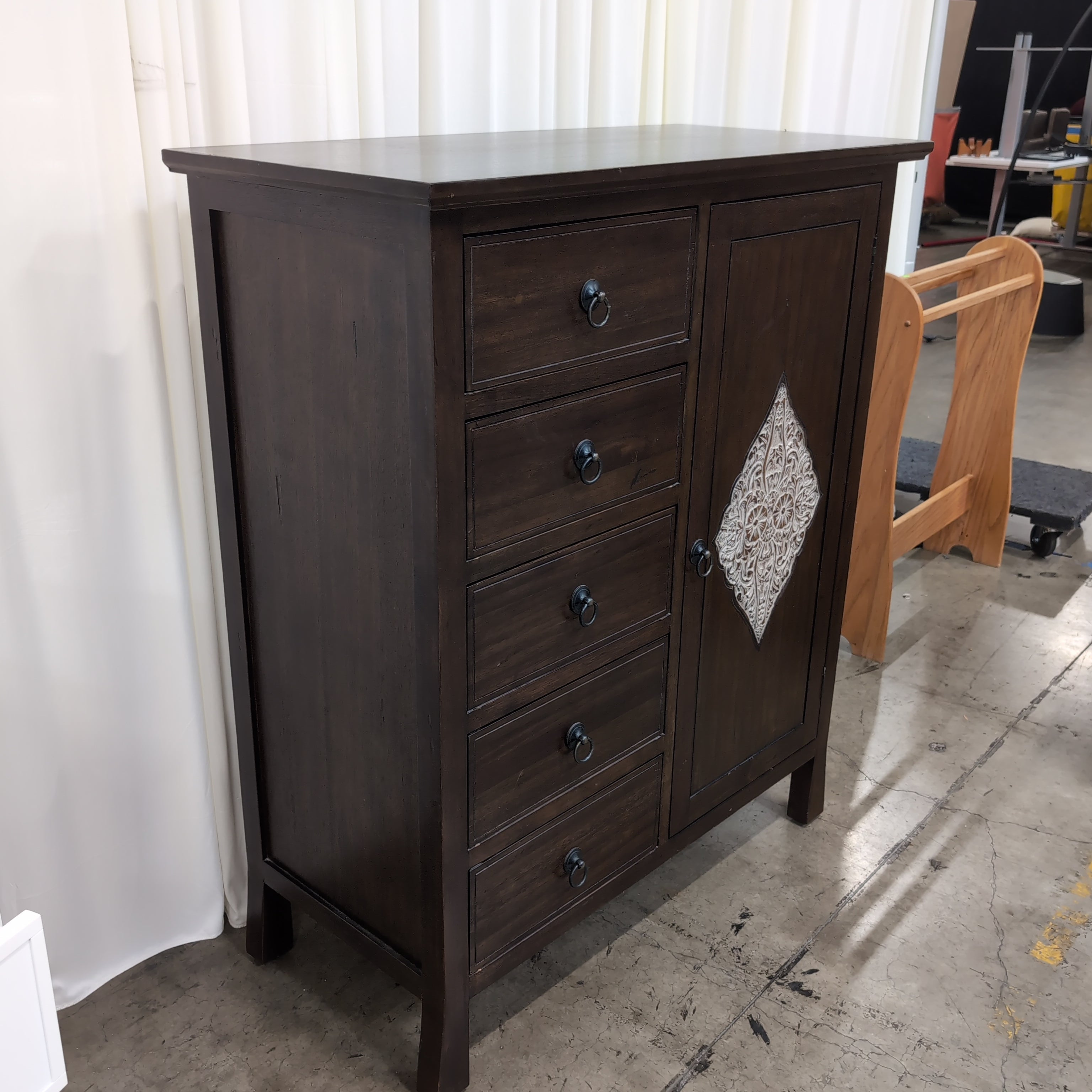 Dark Wood Five-Drawer Dresser with Ornate Panel