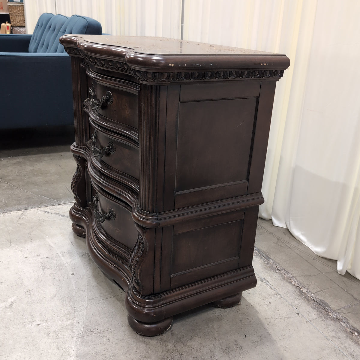 Dark Wood Three-Drawer Nightstand with Ornate Hardware