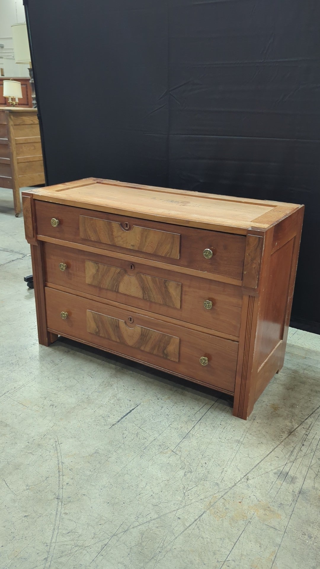 Warm Wood Three-Drawer Dresser with Ornate Hardware