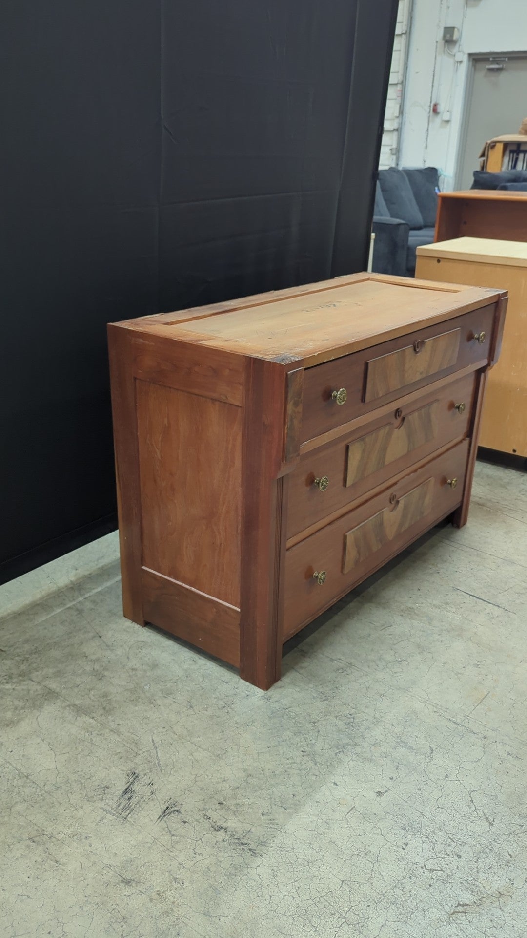 Warm Wood Three-Drawer Dresser with Ornate Hardware