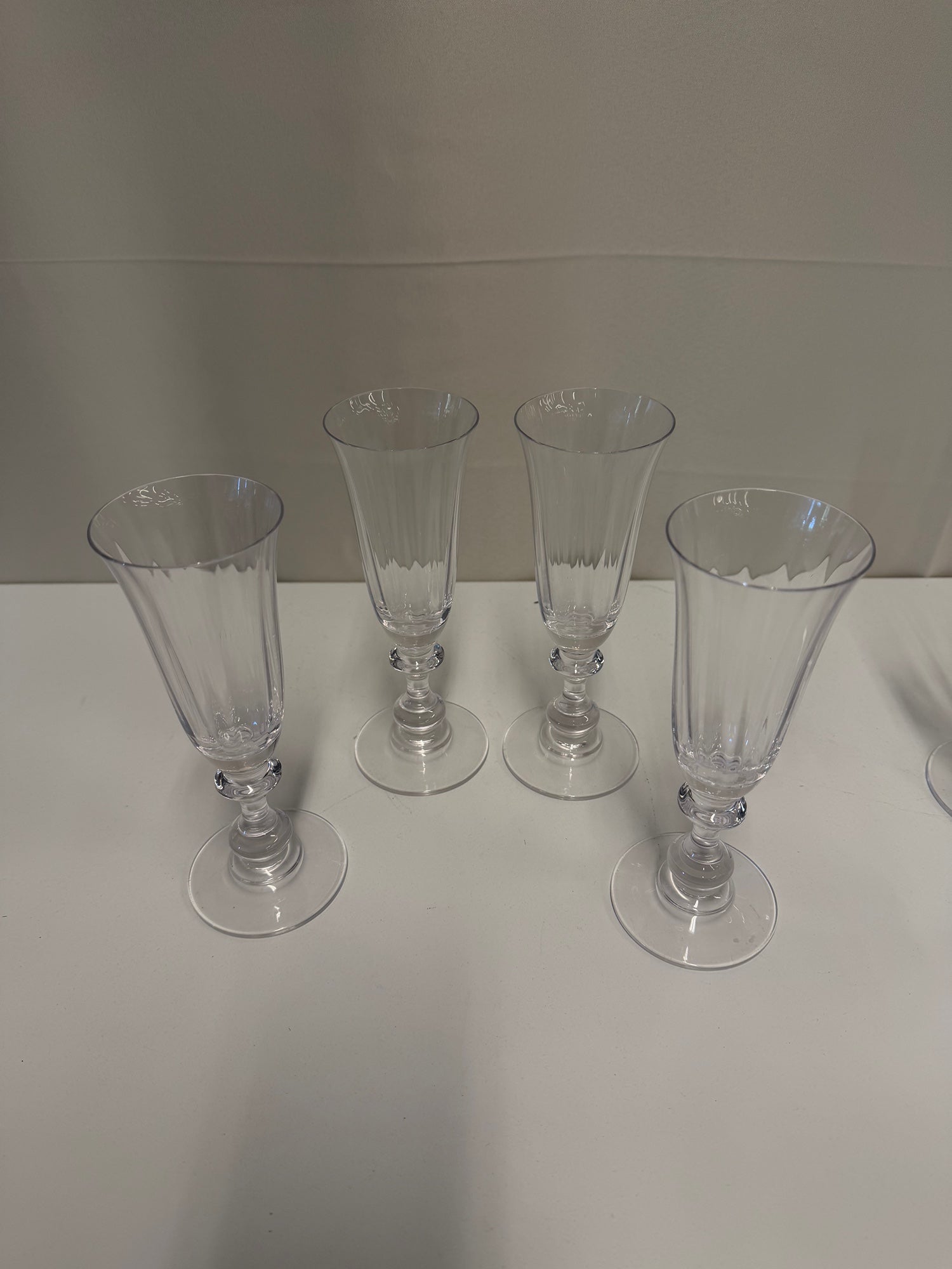 Four Clear Ribbed Glass Champagne Flutes with Decorative Stems