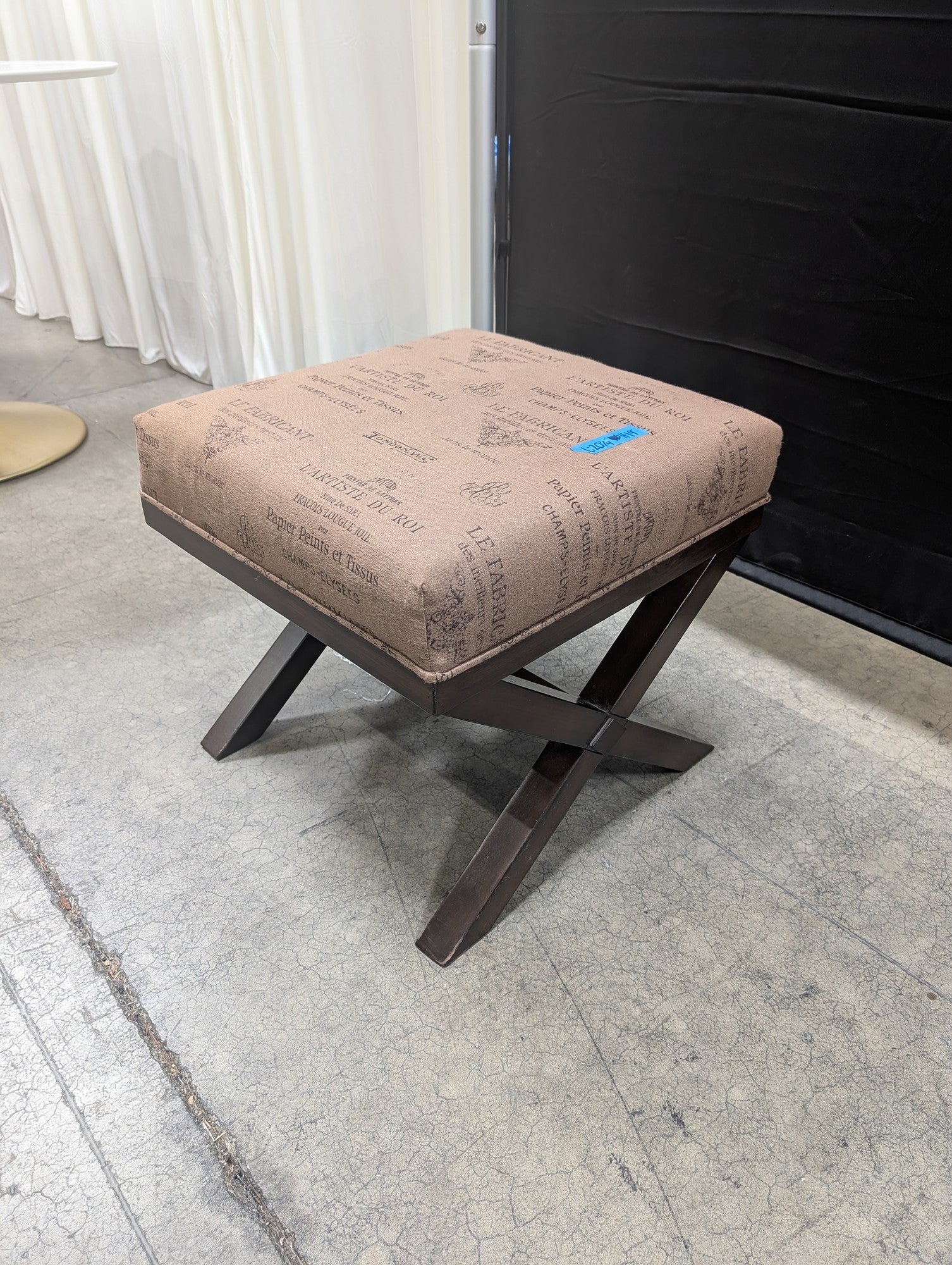 Ashley French Script Upholstered Ottoman with X-Base