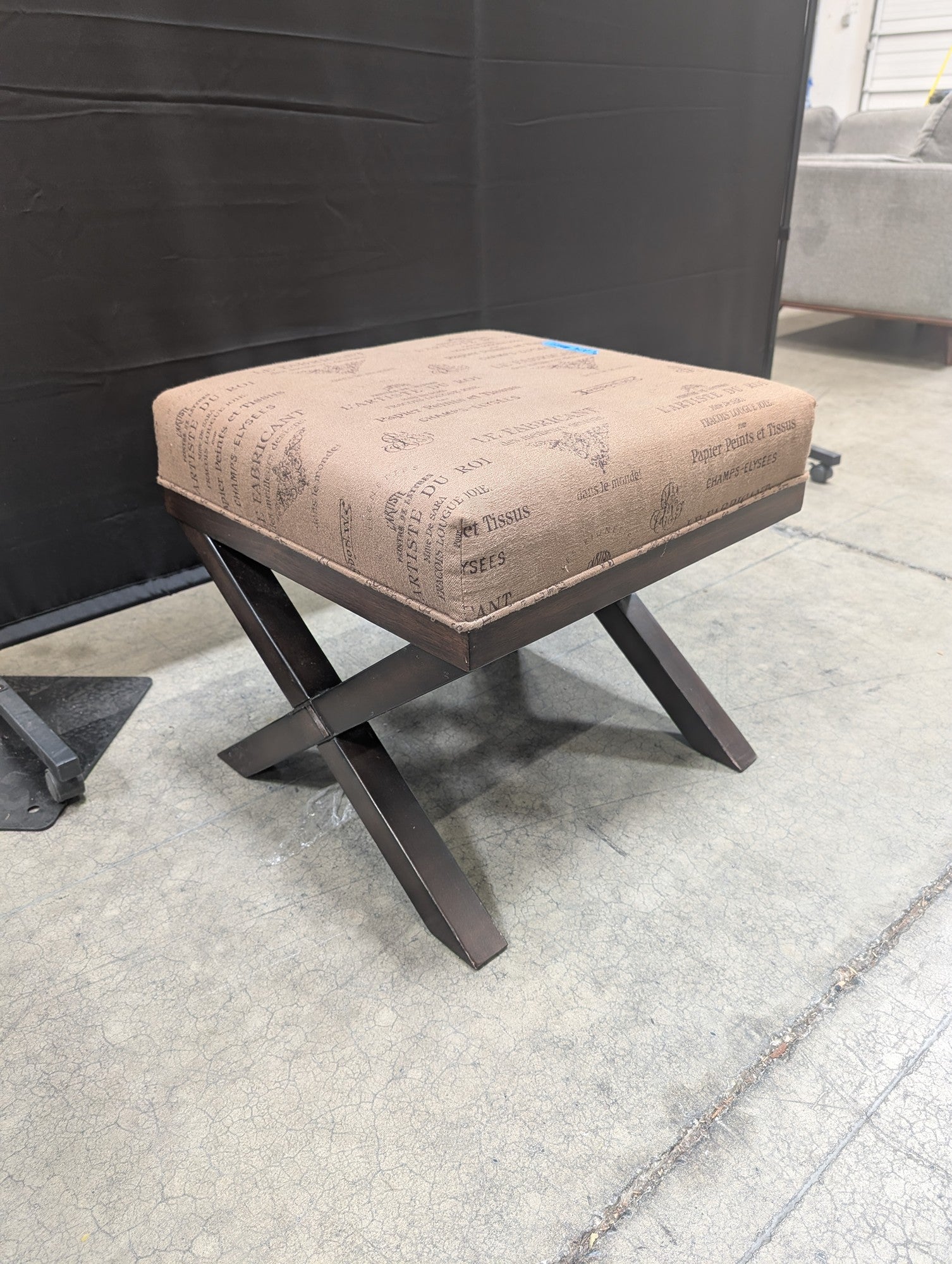Ashley French Script Upholstered Ottoman with X-Base