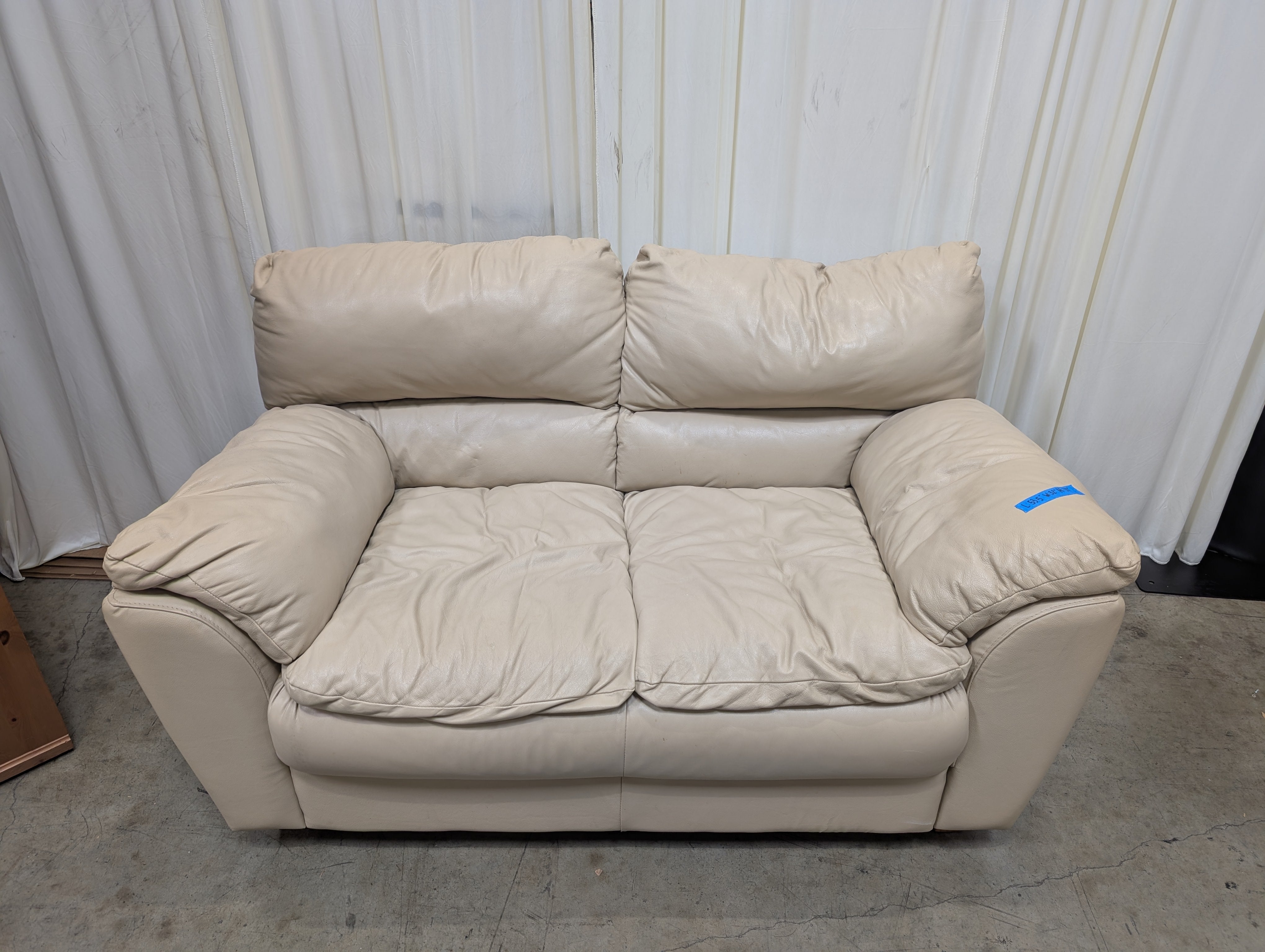 Cream Overstuffed Leather Loveseat with Padded Arms