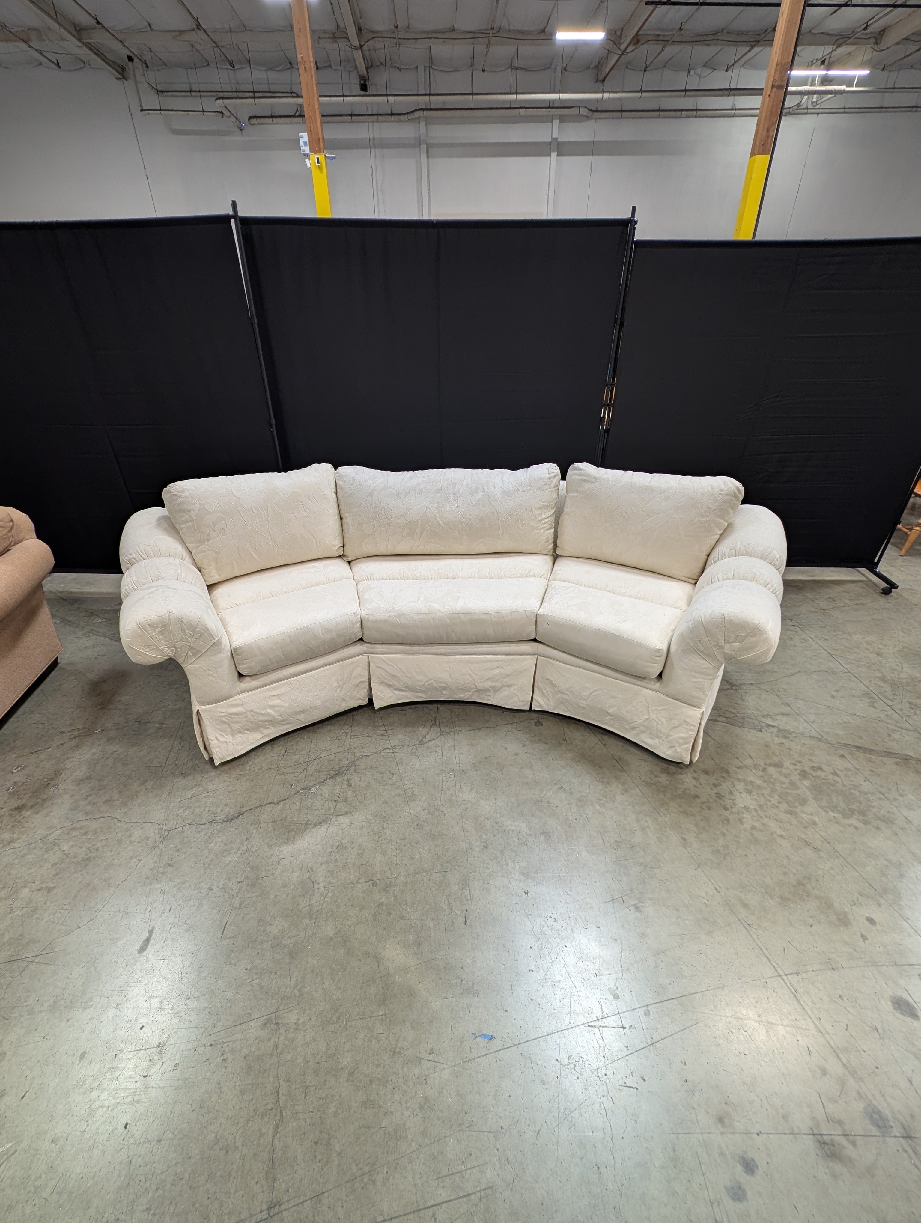 Has a stain Curved Cream Fabric Sectional Sofa with Rolled Arms