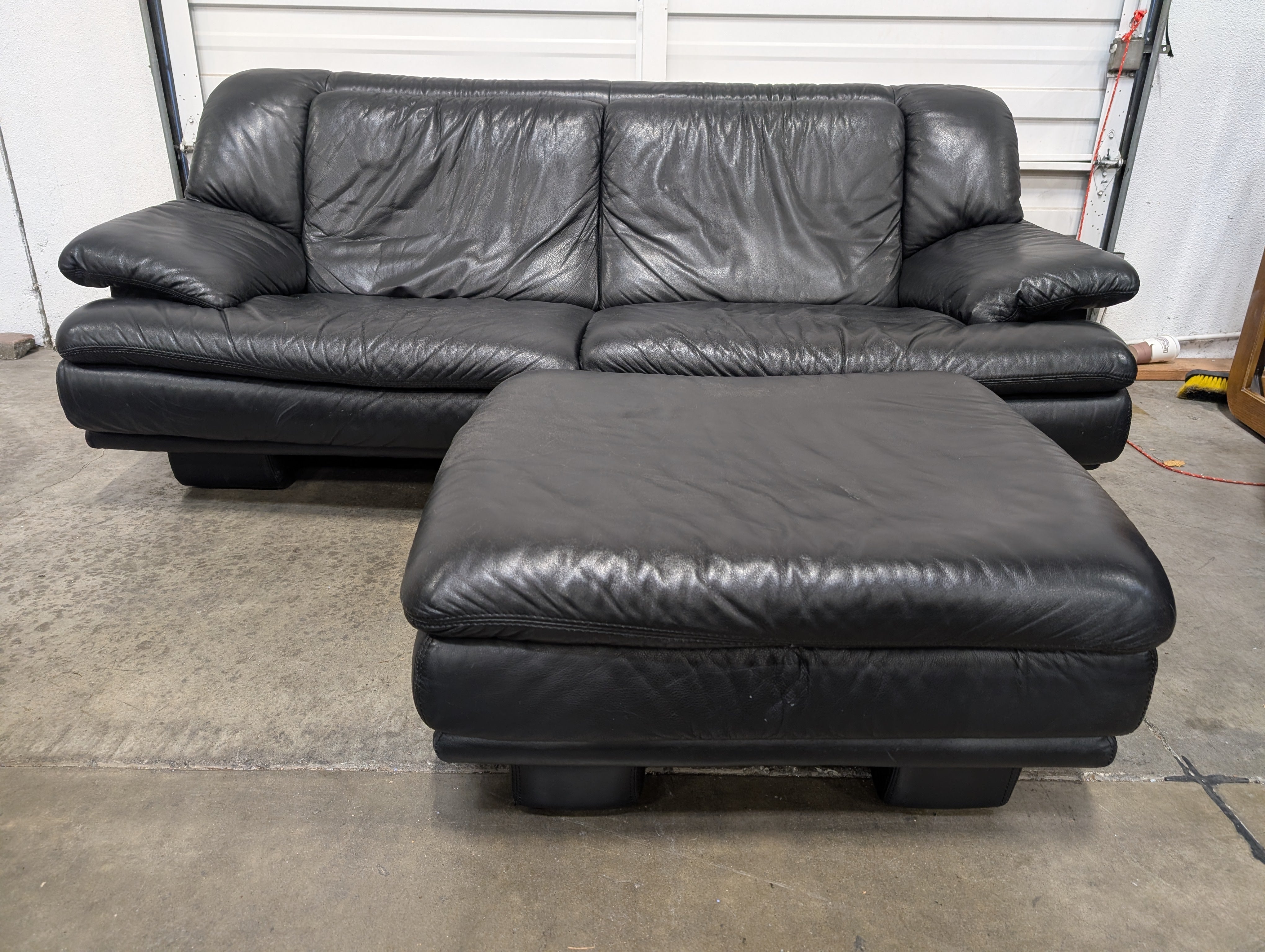 Natuzzi Spacious Black Leather Three-Seater Sofa with Ottoman