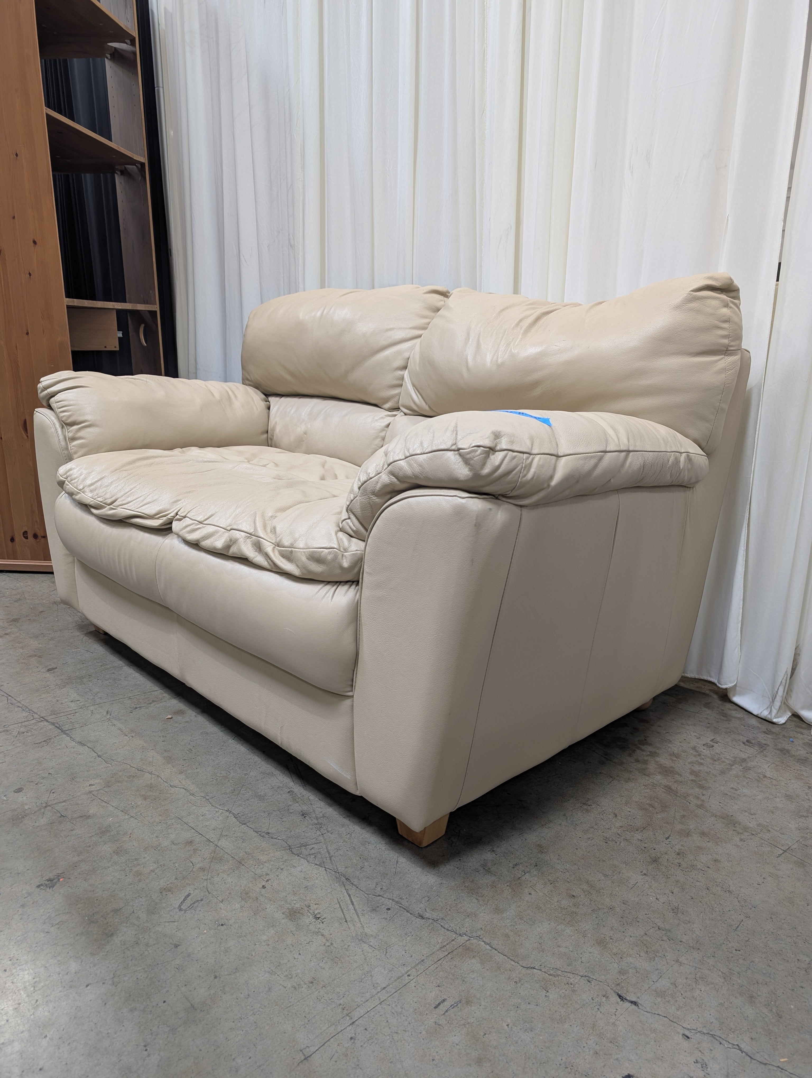 Cream Overstuffed Leather Loveseat with Padded Arms