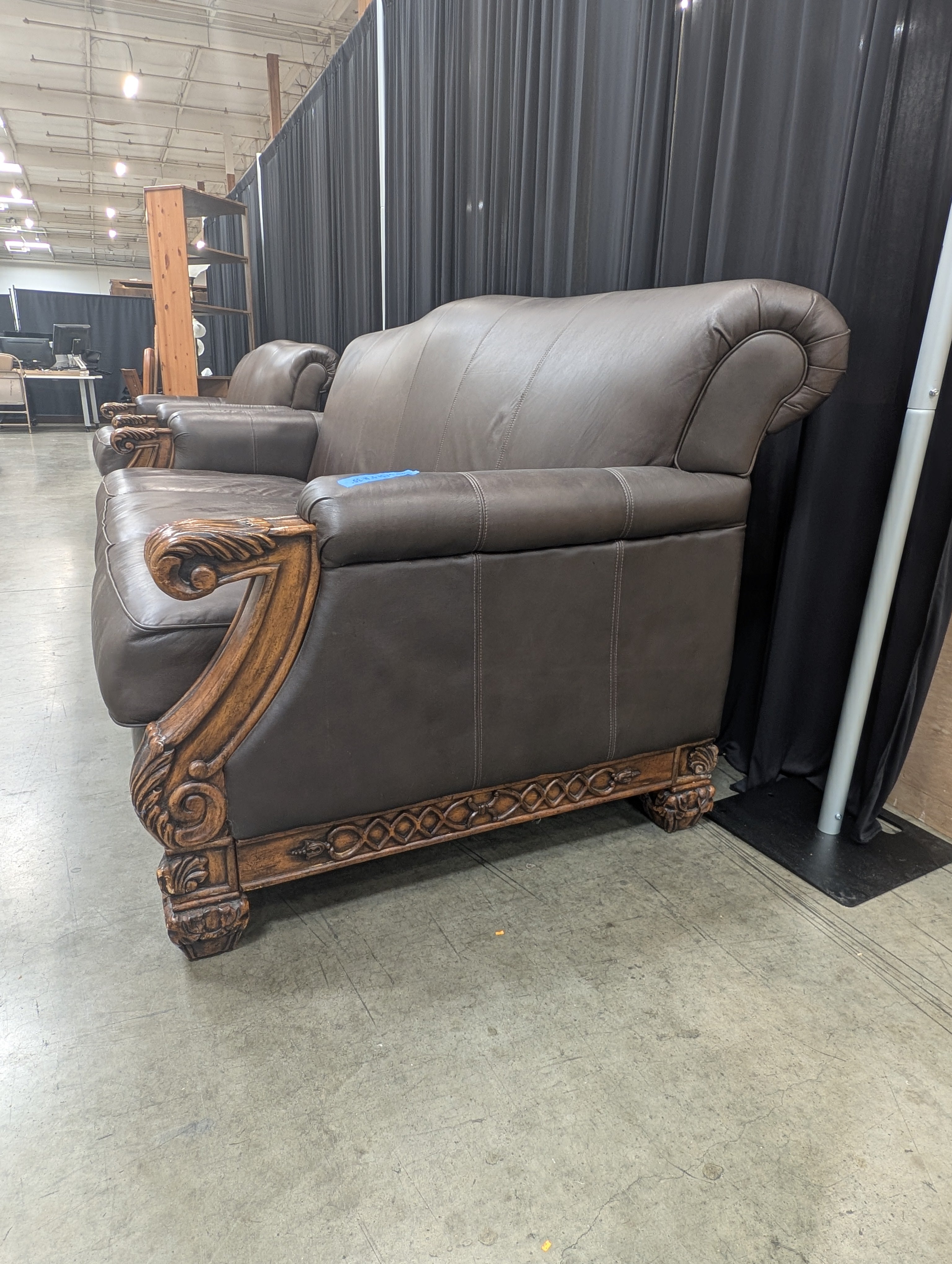 Ornate Brown Leather Couch with Carved Wood Trim