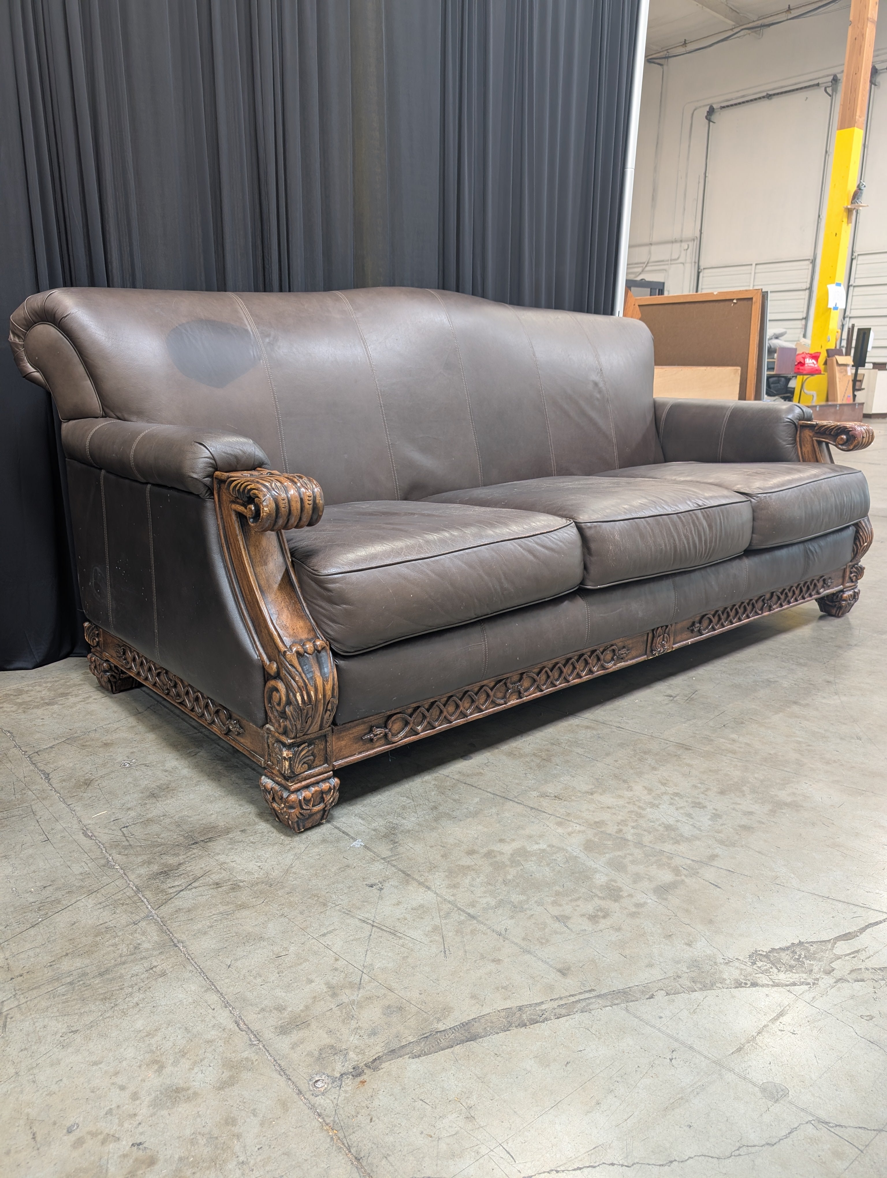 Ornate Brown Leather Couch with Carved Wood Trim