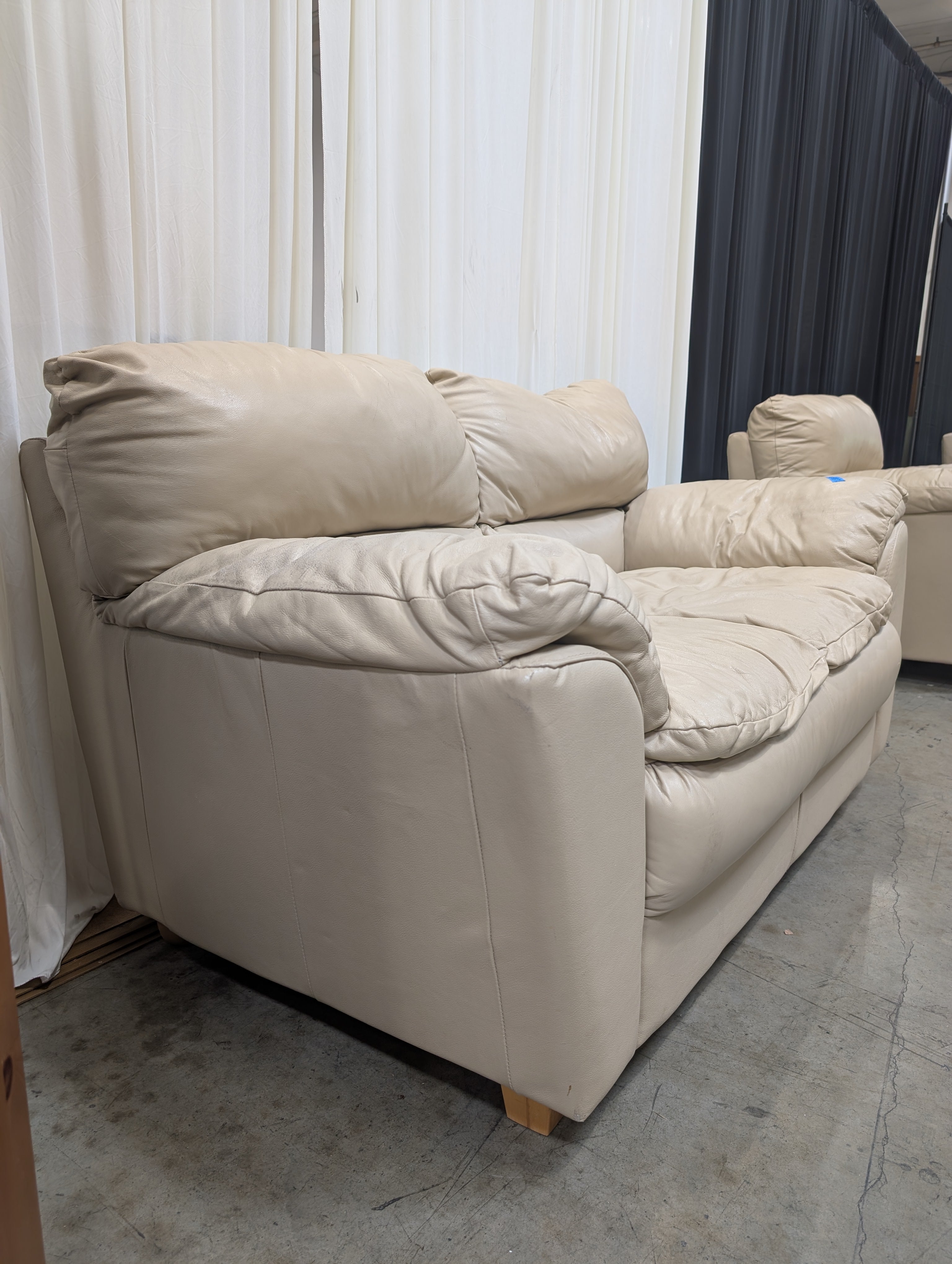 Cream Overstuffed Leather Loveseat with Padded Arms