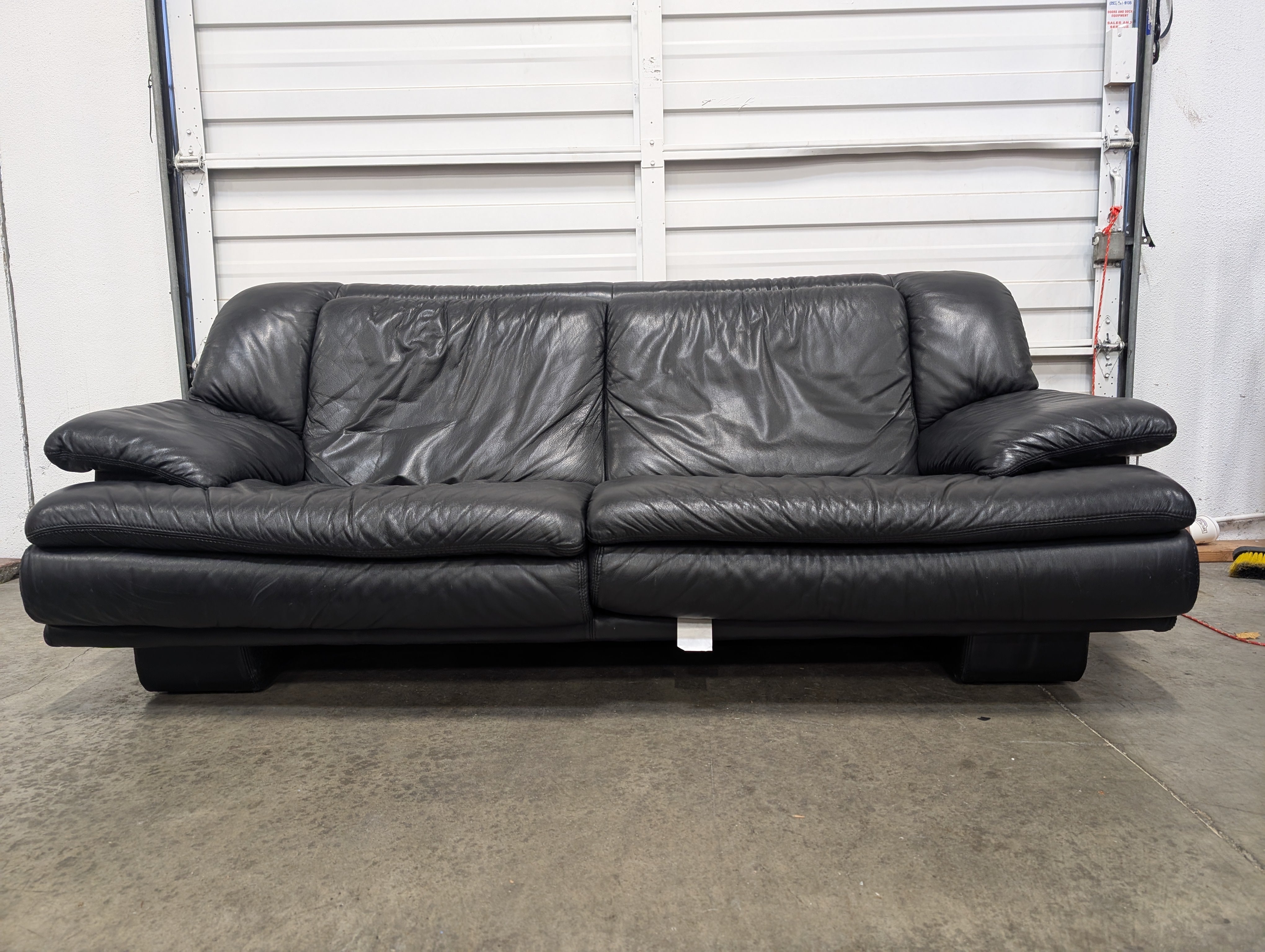 Natuzzi Spacious Black Leather Three-Seater Sofa with Ottoman