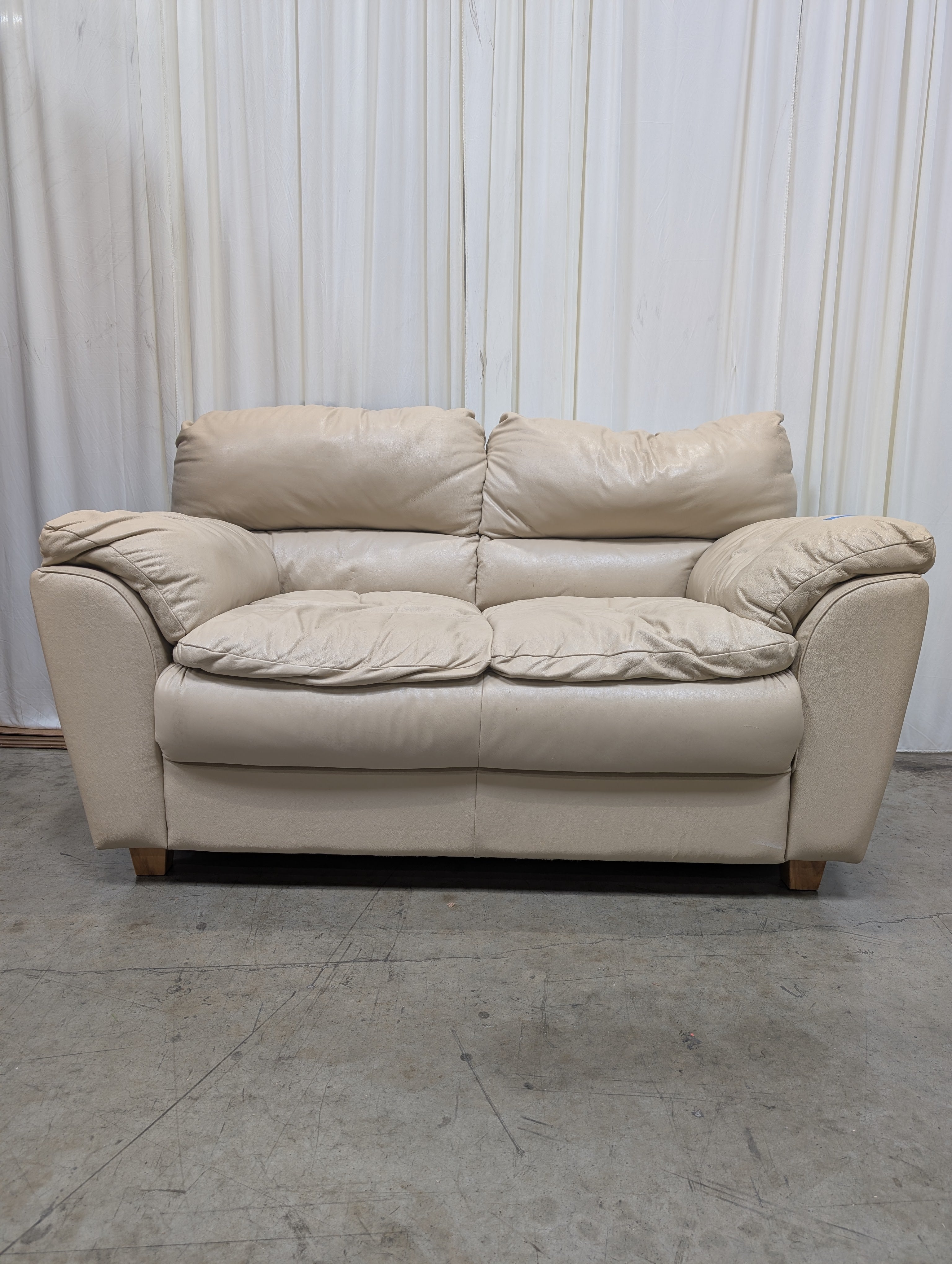 Cream Overstuffed Leather Loveseat with Padded Arms