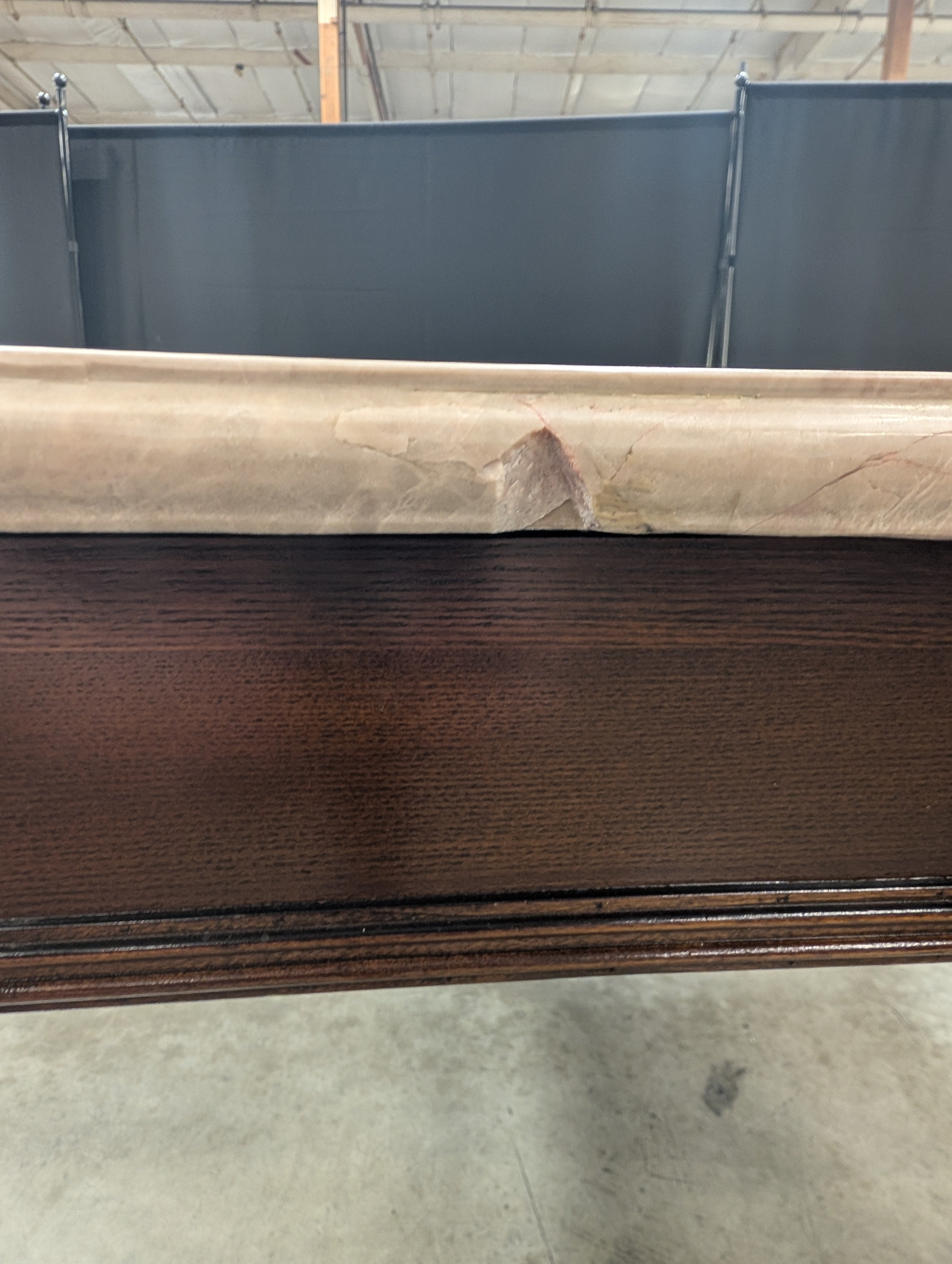 Stone Top Dining Table with Tapered Wood Legs has chip