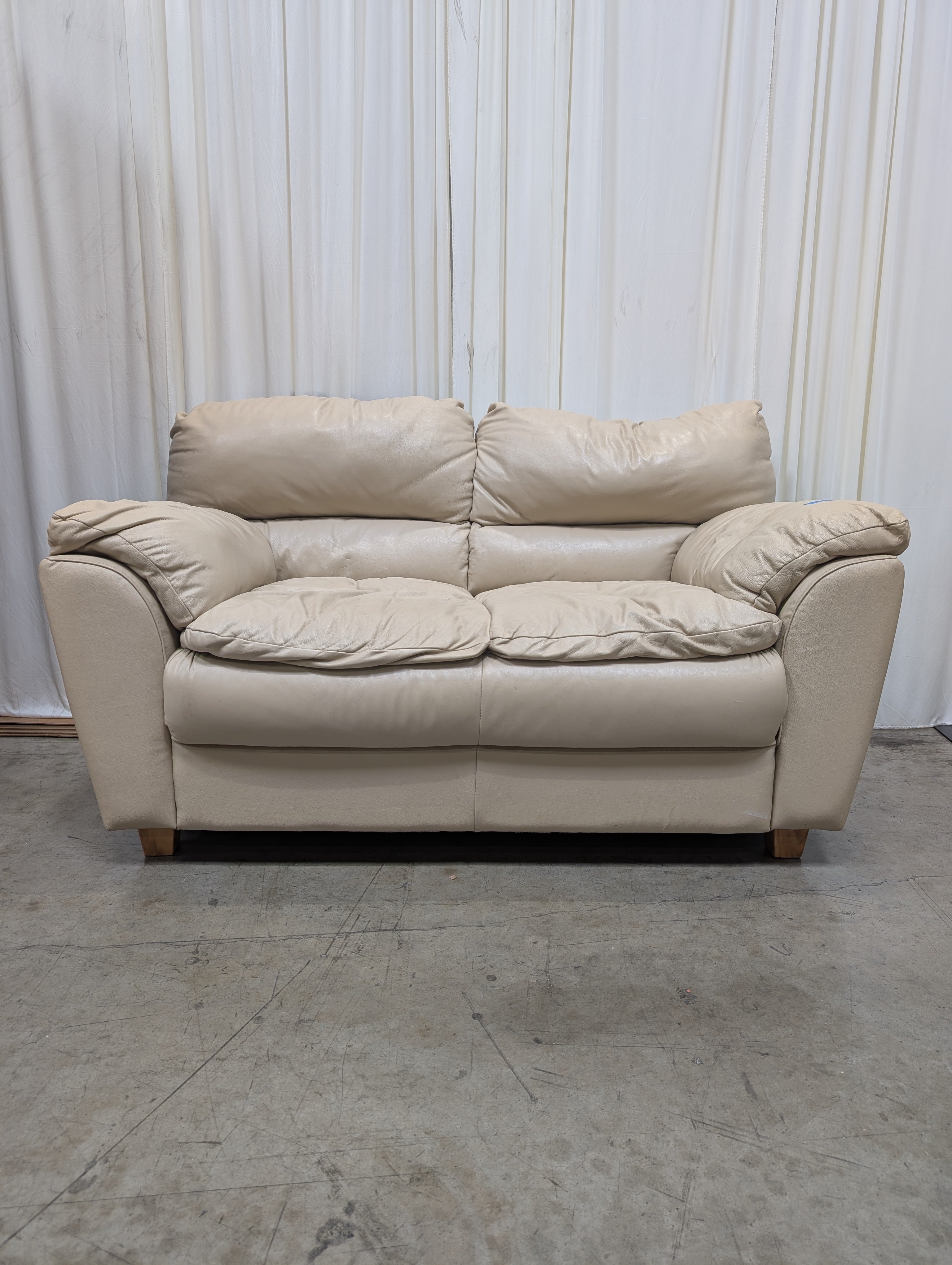 Cream Overstuffed Leather Loveseat with Padded Arms