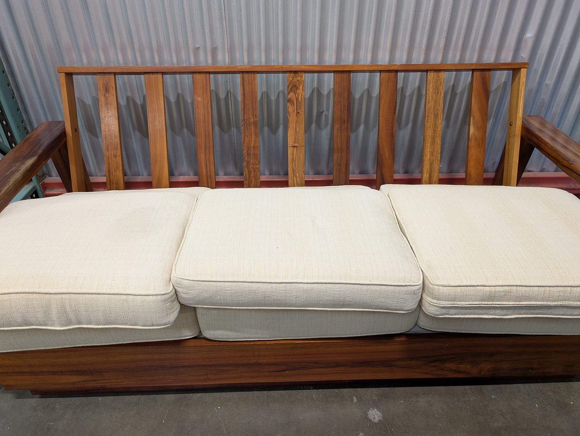 Mid-Century Style Wooden Sofa with Carved Leaf Arms and Cream Cushions