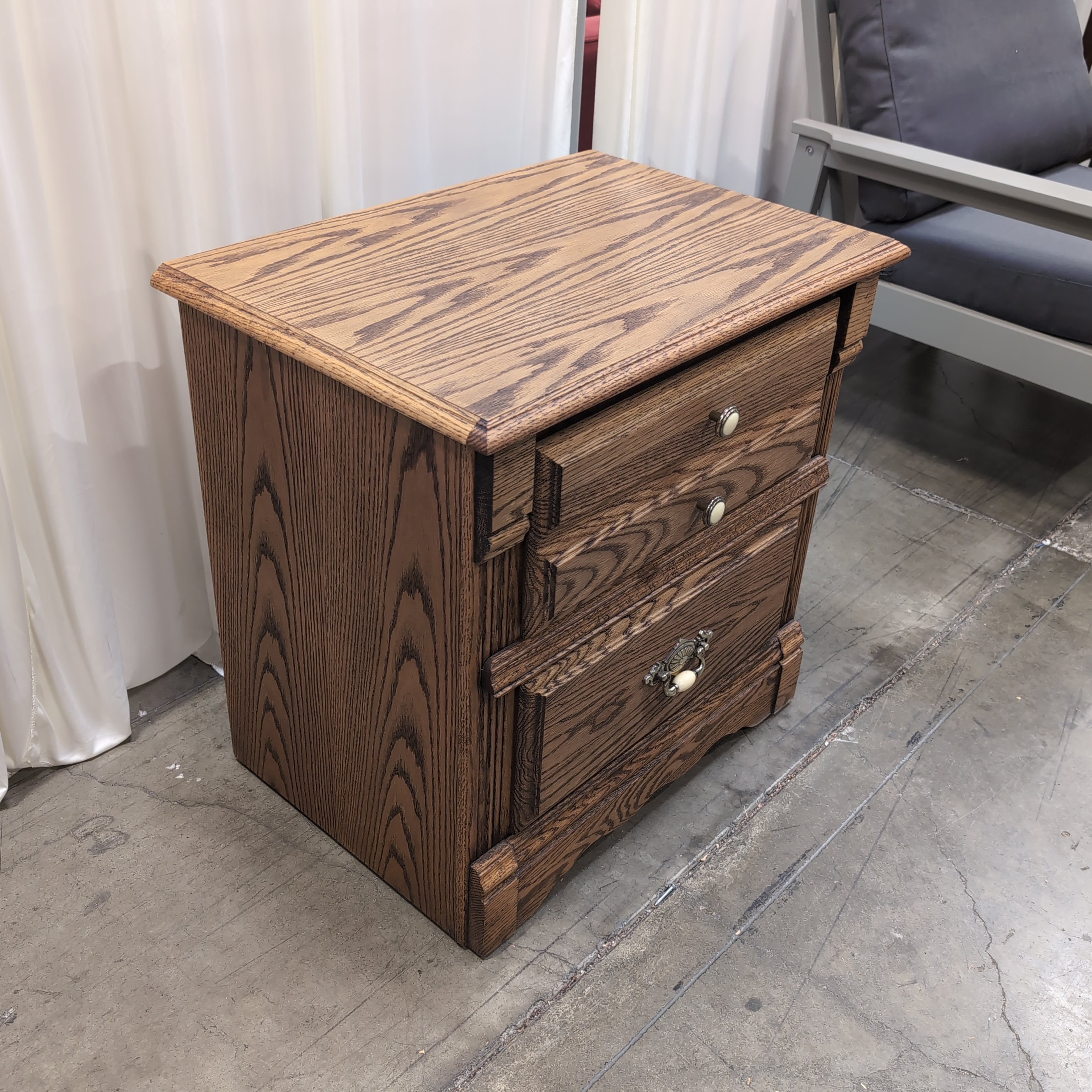 Brown Wood Three-Drawer Nightstand with Ornate Hardware