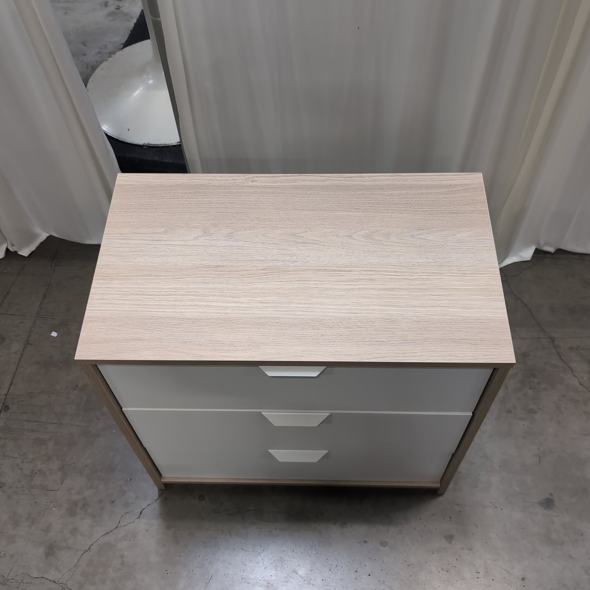 Light Wood Three-Drawer Nightstand with Recessed Pulls