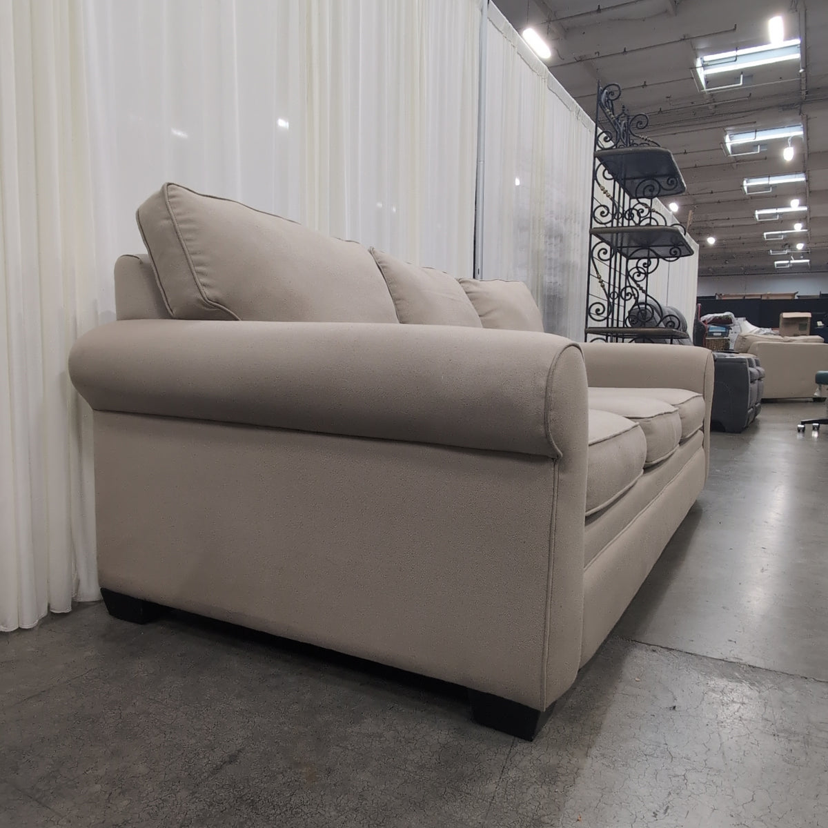 Tan Fabric Three-Cushion Couch with Rolled Arms