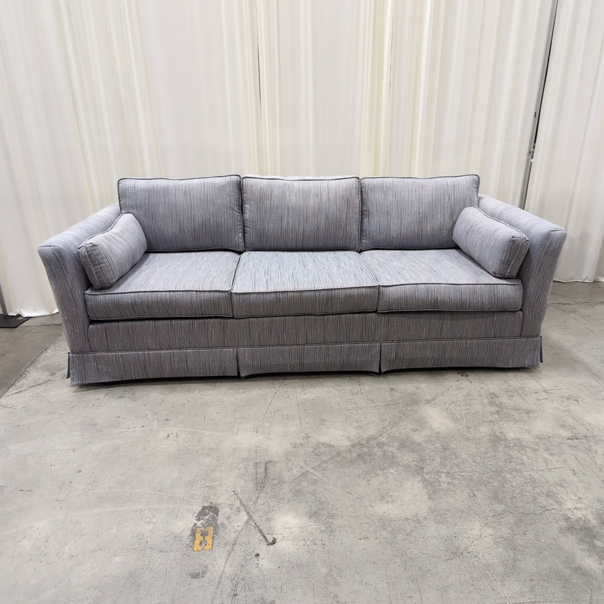 Textured Gray Three-Cushion Couch with Skirted Base