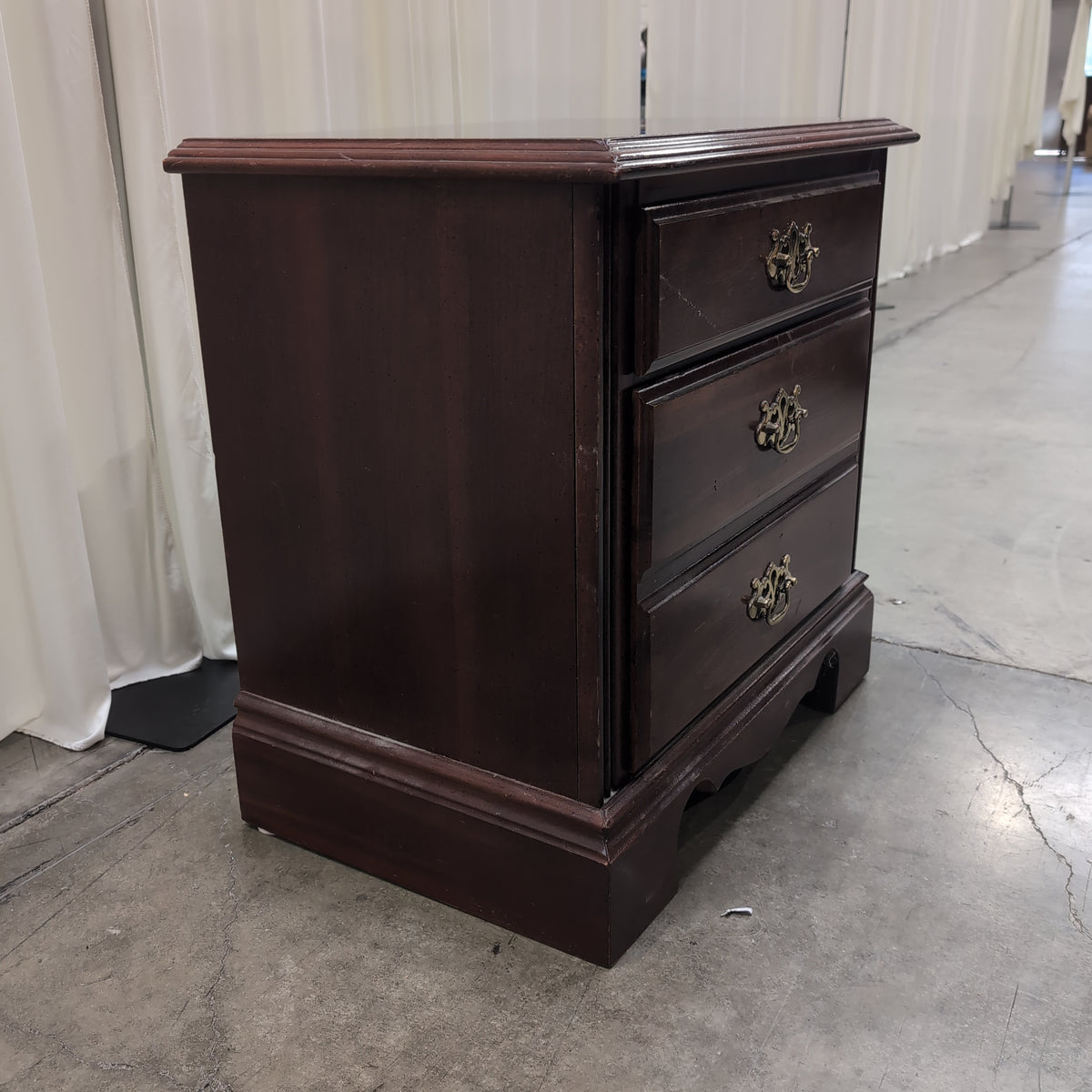 Traditional Dark Wood Three-Drawer Nightstand with Ornate Hardware