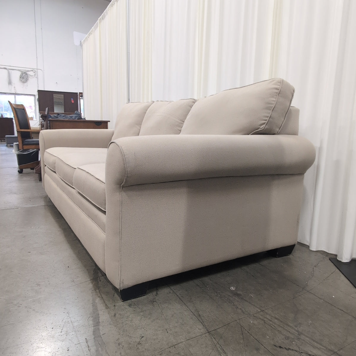 Tan Fabric Three-Cushion Couch with Rolled Arms
