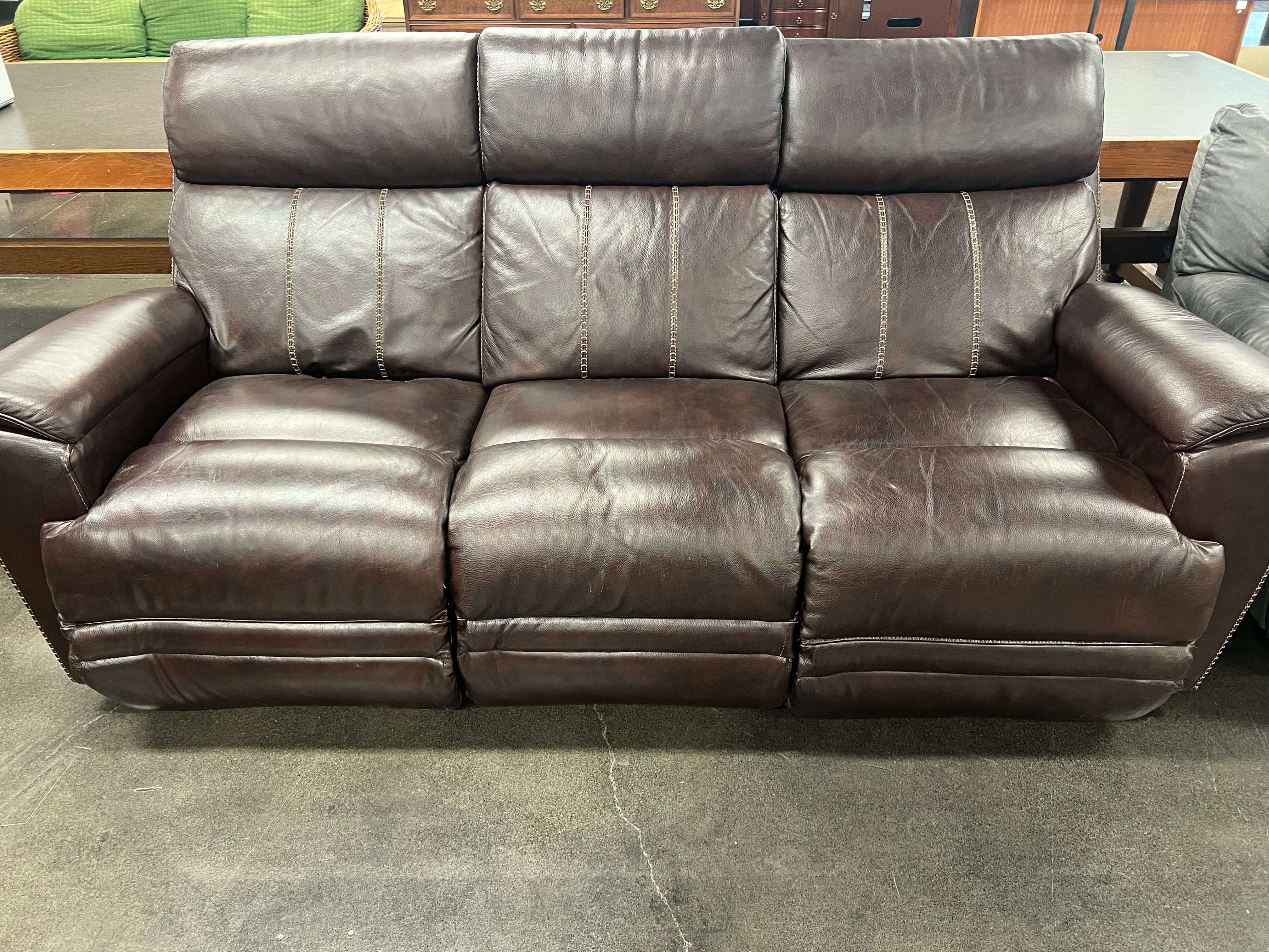 A brown faux leather recliner couch with built-in USB charging ports, featuring a three-seater design.