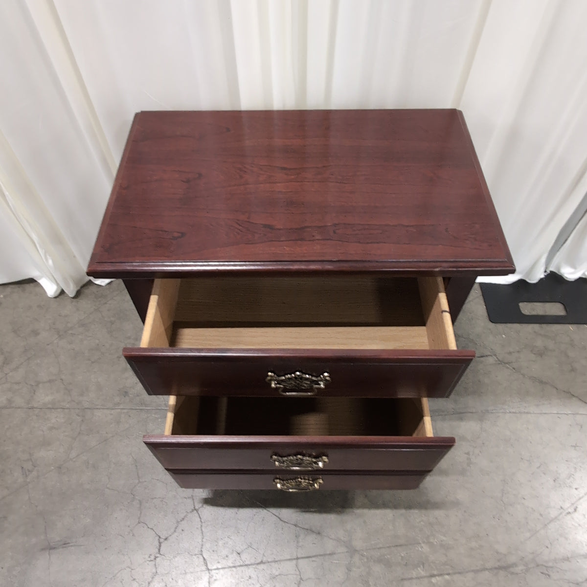 Dark Wood Three-Drawer Nightstand with Ornate Hardware