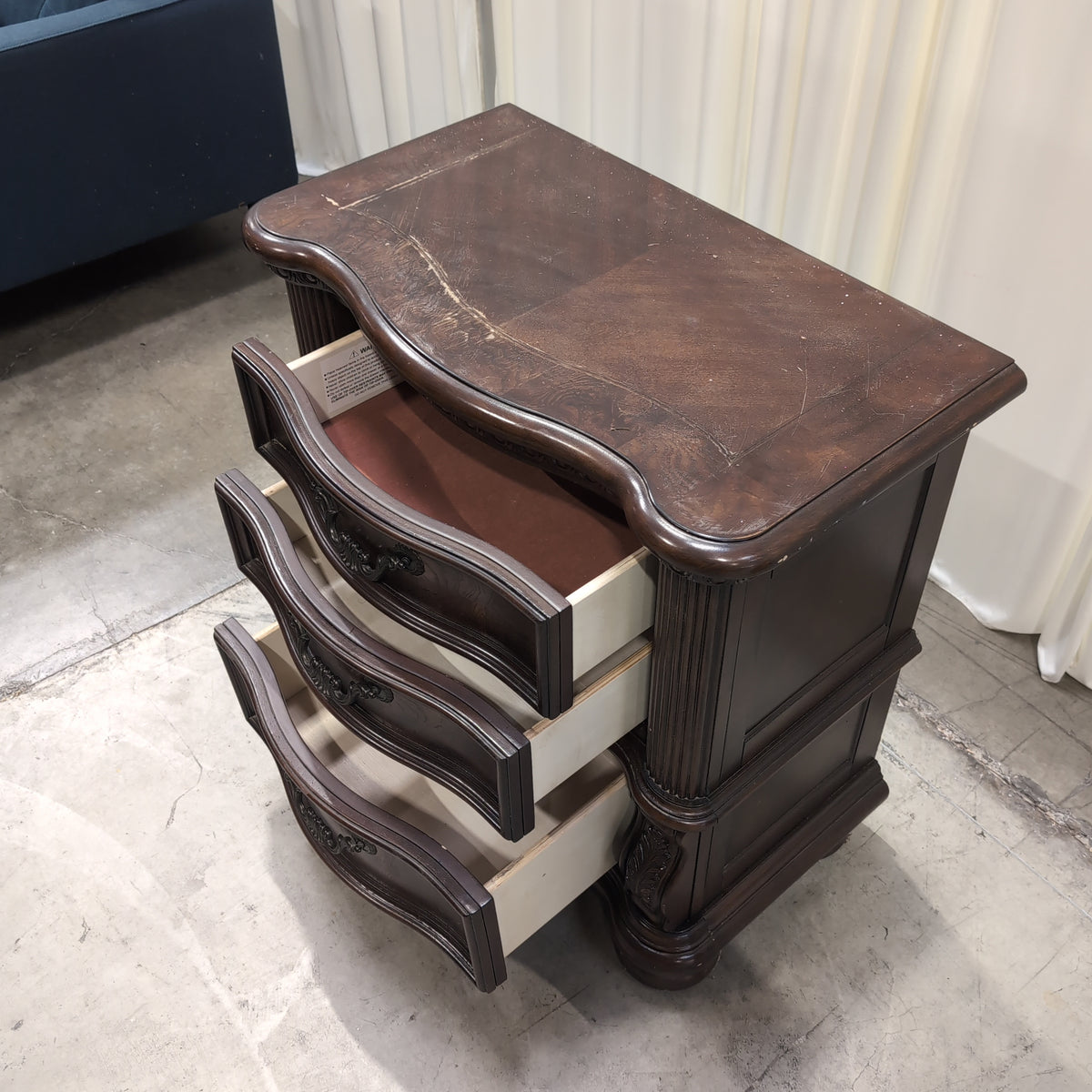 Dark Wood Three-Drawer Nightstand with Ornate Hardware