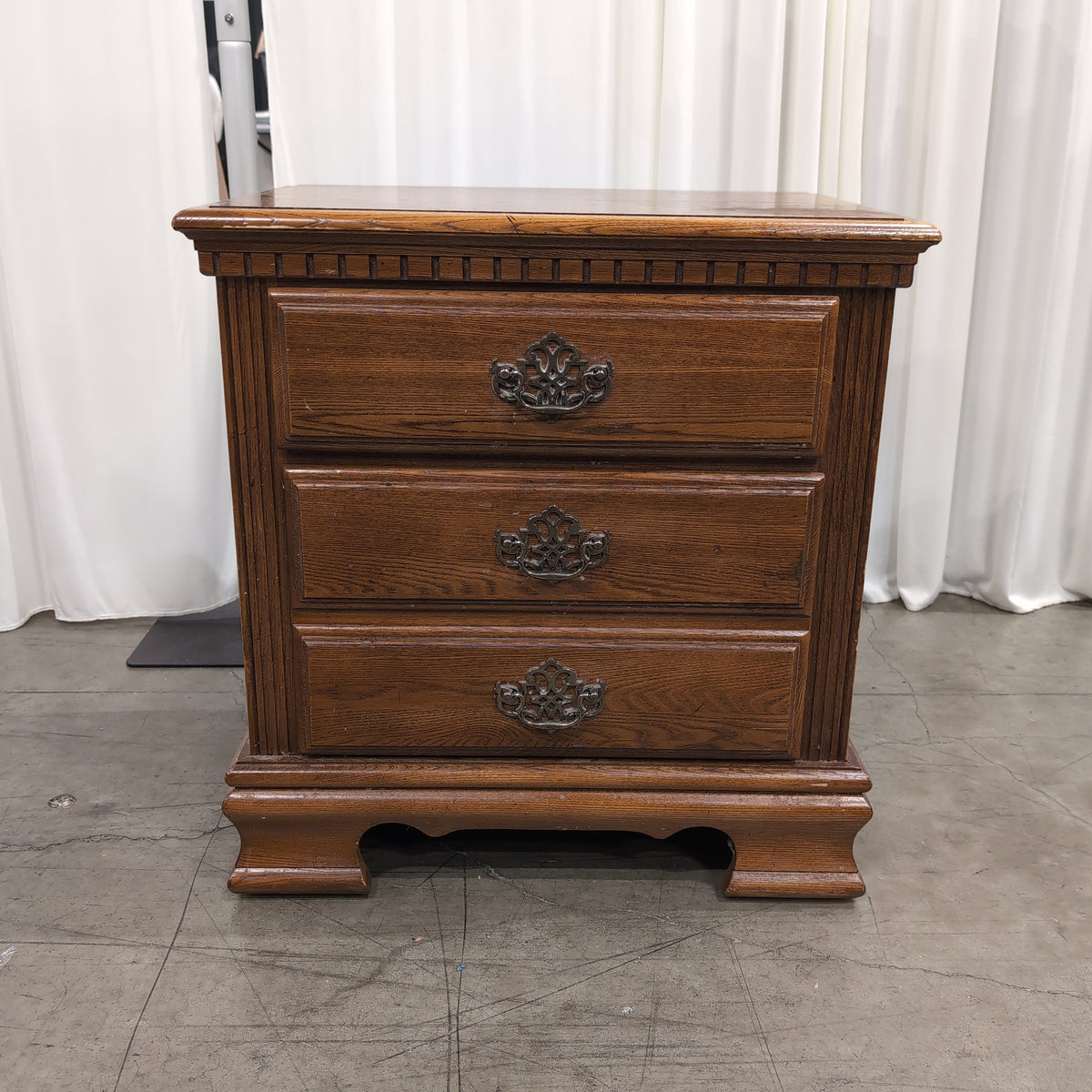 Traditional Brown Wood Three-Drawer Nightstand with Ornate Hardware