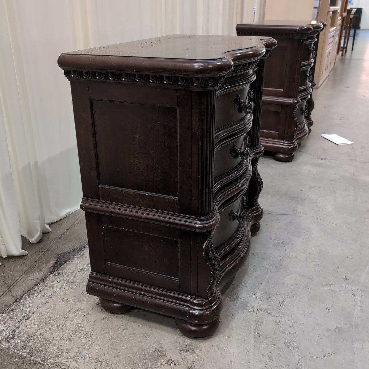 Dark Wood Three-Drawer Nightstand with Ornate Hardware