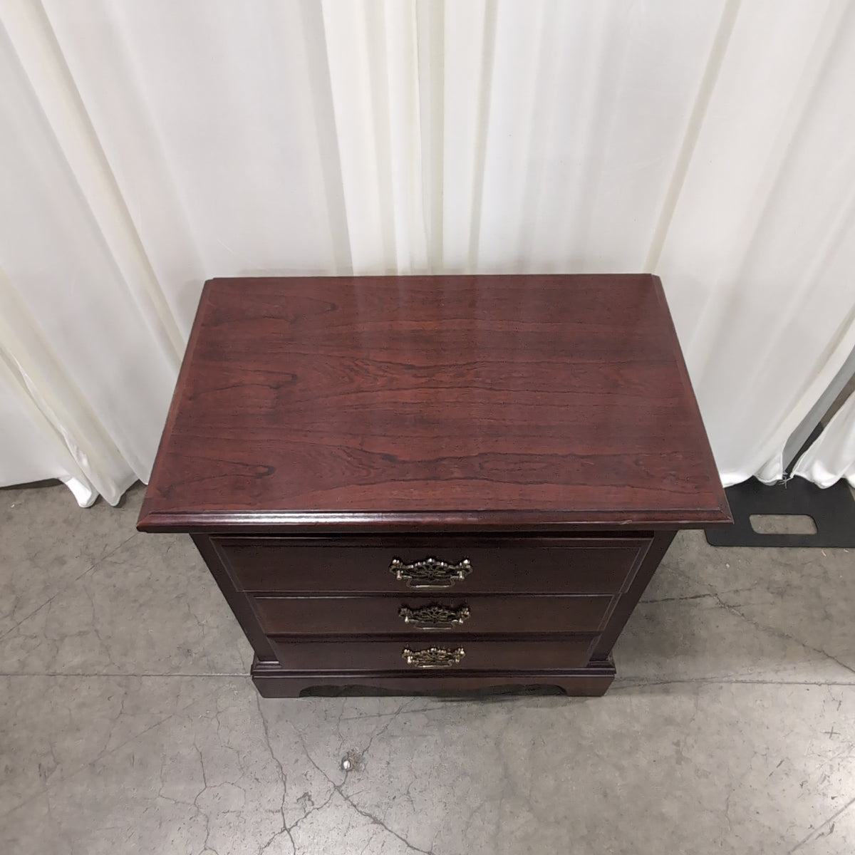 Dark Wood Three-Drawer Nightstand with Ornate Hardware