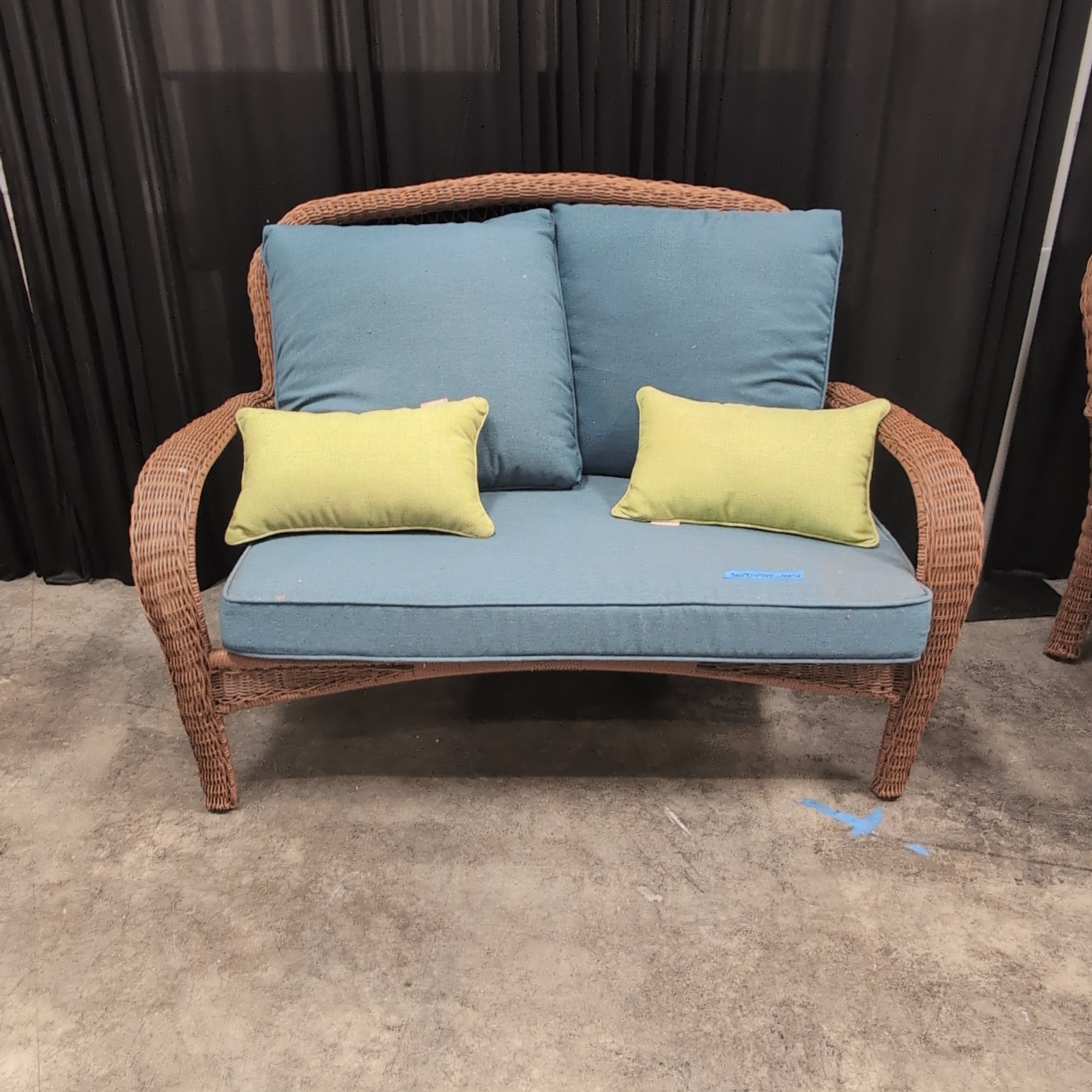 Brown Wicker Outdoor Loveseat with Blue Cushions