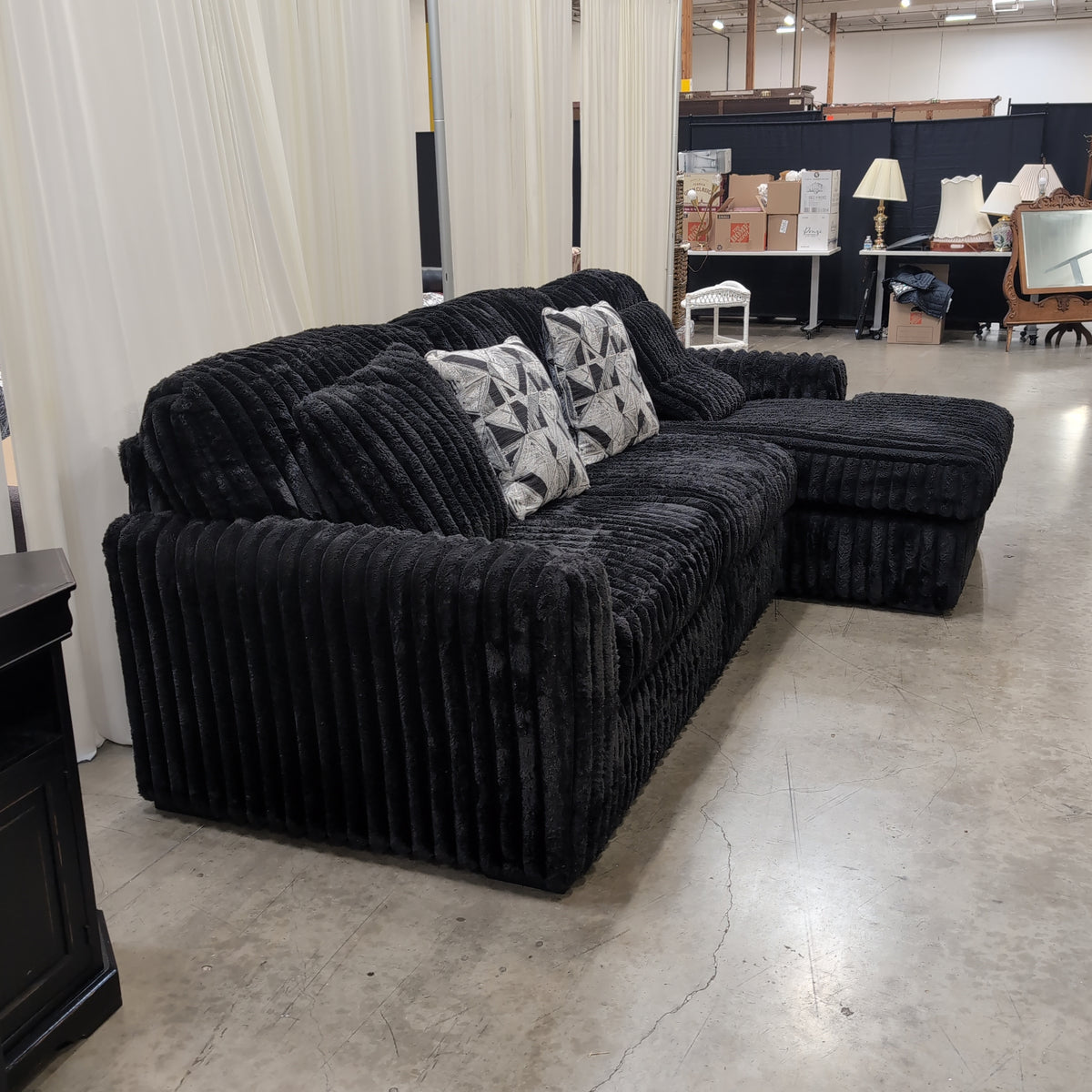 Black Ribbed Plush Sectional Couch with Geometric Throw Pillows