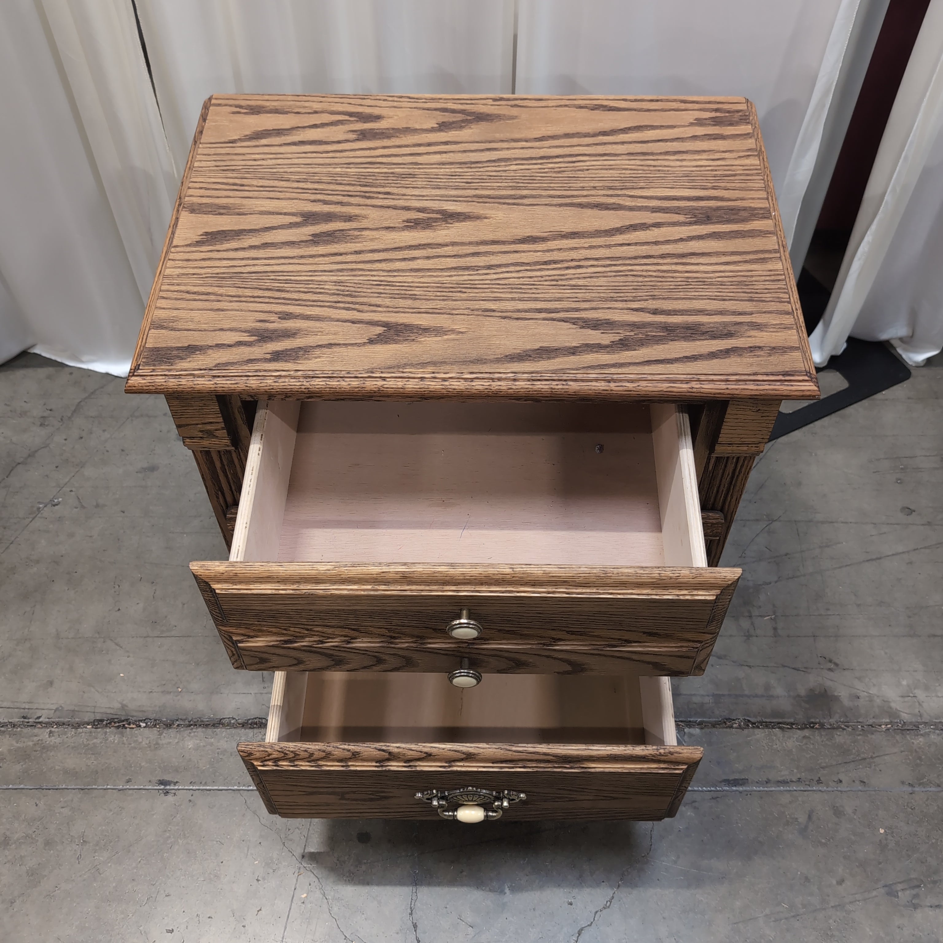 Brown Wood Three-Drawer Nightstand with Ornate Hardware