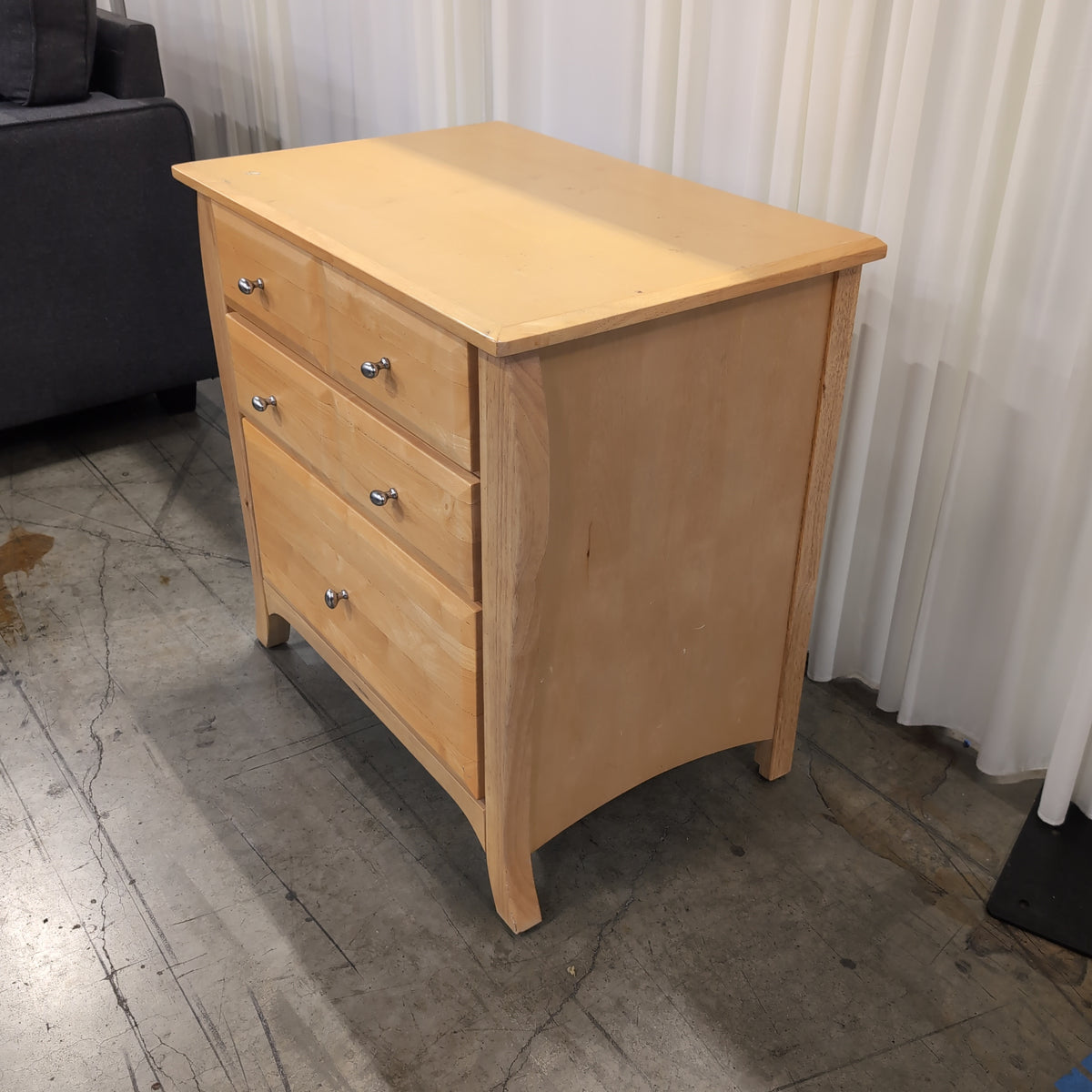 Light Wood Three-Drawer Nightstand with Curved Sides